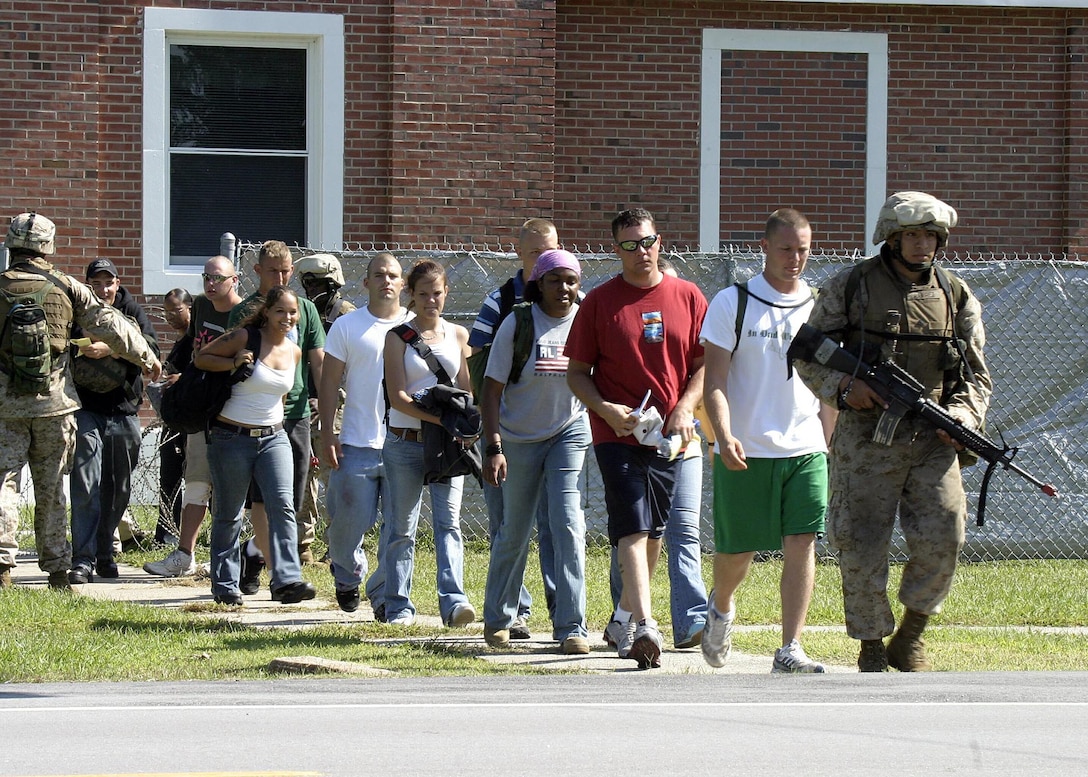 Marines from Golf Battery, Battalion Landing Team 1st Bn., 2nd Marines evacuate American citizens during a non-combatant evacuation operation (NEO) exercise aboard Camp Lejeune during the 22nd Marine Expeditionary Unit's recent Certification Exercise (CERTEX) Oct. 2, 2005.  CERTEX was the final predeployment exercise undertaken by the MEU before it deploys later this year.