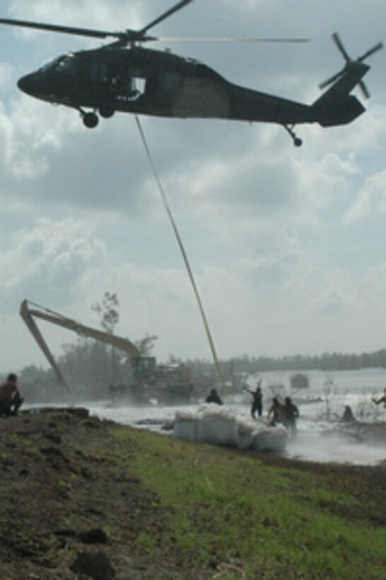 A Minnesota Army National Guard UH-60 Black Hawk helicopter prepares to release the sling after positioning a 3,000-pound sandbag on one of five breached levees in the Braithwaite to Scarsdale levee system in northern Plaquemines Parish, La., on Sept. 29, 2005. Department of Defense units are mobilized as part of Joint Task Force Katrina to support the Federal Emergency Management Agency's disaster-relief efforts in the Gulf Coast areas devastated by Hurricane Katrina. 