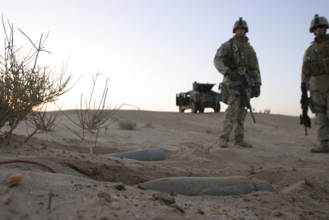 U.S. Marines discovered two 155mm artillery shells (foreground) with red detonation wires on the heads near the Long Island bridge in Al Taqaddum, Iraq, on Sept. 30, 2005. U.S. Marines of the 2nd Squad, 1st Platoon, Military Police Company are performing mounted and dismounted patrols to prevent insurgents from placing improvised explosive devices. 