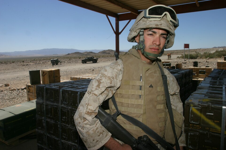 Cpl. Roberto Mundo, an ammunition technician who spent his formative years growing up in Carolina, Puerto Rico, before relocating with his family to Columbia, S.C., stands guard at an ammunition supply point at Marine Corps Air Ground Combat Center, Twentynine Palms, Calif.