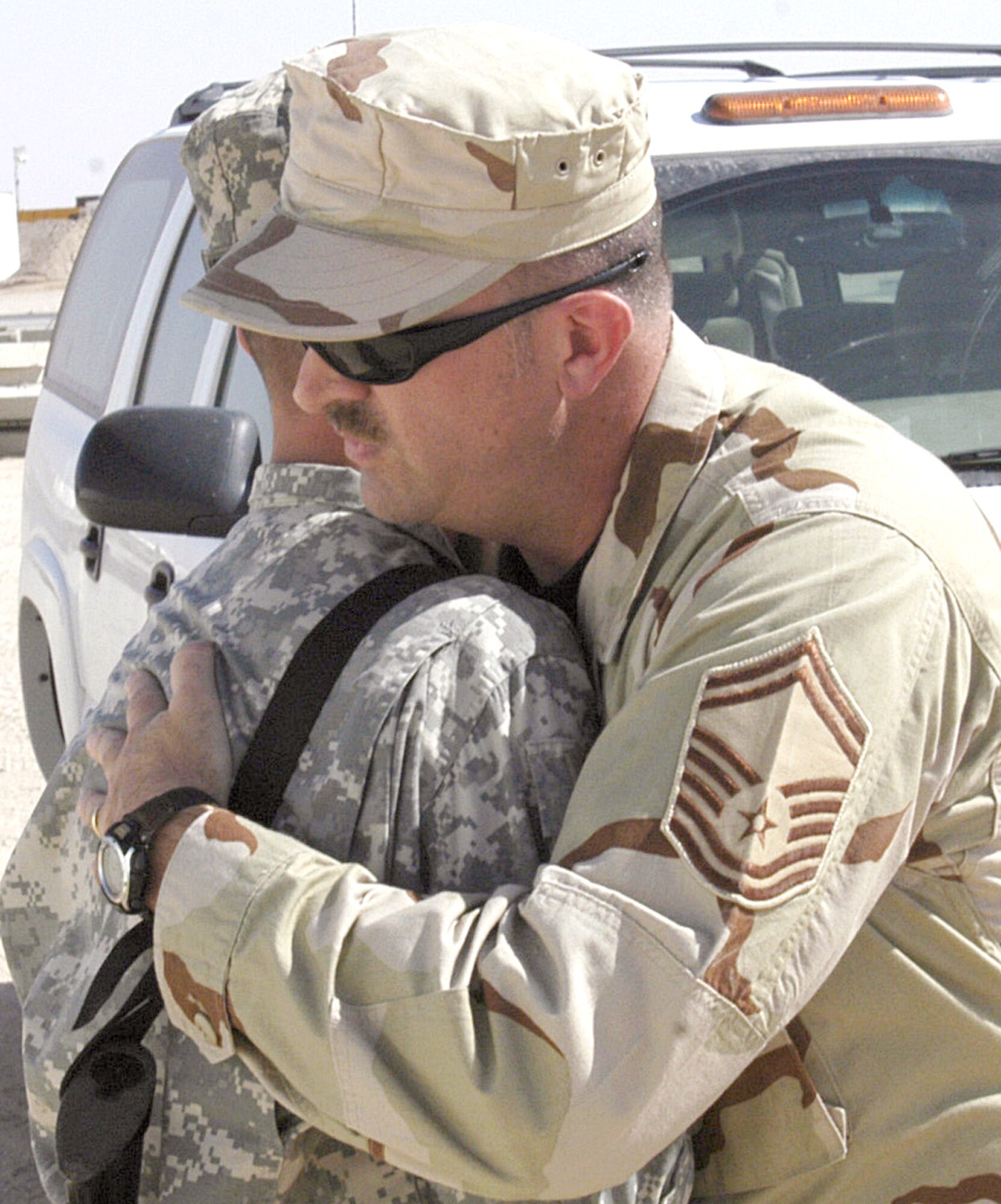 SOUTHEAST ASIA -- Senior Master Sgt. James Sedoris hugs his son, Army Pfc. Weston Sedoris, one last time before departing an Army camp where the two enjoyed an unexpected reunion. Sergeant Sedoris recently came across his son while dropping off some Airmen for a briefing at the Army camp. Sergeant Sedoris is assigned to the 386th Expeditionary Medical Group at a forward-deployed location. (U.S. Air Force photo by Staff Sgt. Scott Campbell.)