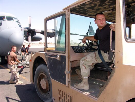 SOUTHWEST ASIA -- Airman 1st Class David Burke (right) and Senior Airman Richard Murdock tow a C-130 Hercules to its parking spot in preparation for an arriving aircrew.  The Airmen are assigned to the 386th Expeditionary Aircraft Maintenance Squadron and are deployed from Pope Air Force Base, N.C.  (U.S. Air Force photo by Master Sgt. Alfred A. Gerloff Jr.)