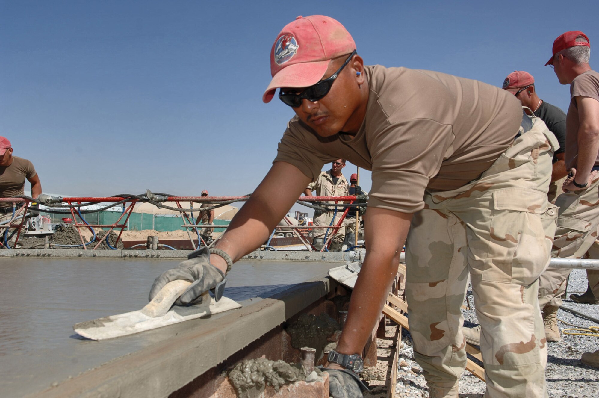 BAGRAM AIR BASE, Afghanistan -- Tech. Sgt. John Narvarte smoothes freshly poured concrete for the newest section of aircraft parking ramp here. The 1st Expeditionary Red Horse Group from Nellis Air Force Base, Nev., is adding an additional 60,000 square meters of aircraft ramp space as part of a $4.4-million airfield upgrade project. Sergeant Narvarte is a pavement and construction equipment craftsman with the 1st ERHG. (U.S. Air Force photo by Capt. James H. Cunningham) 