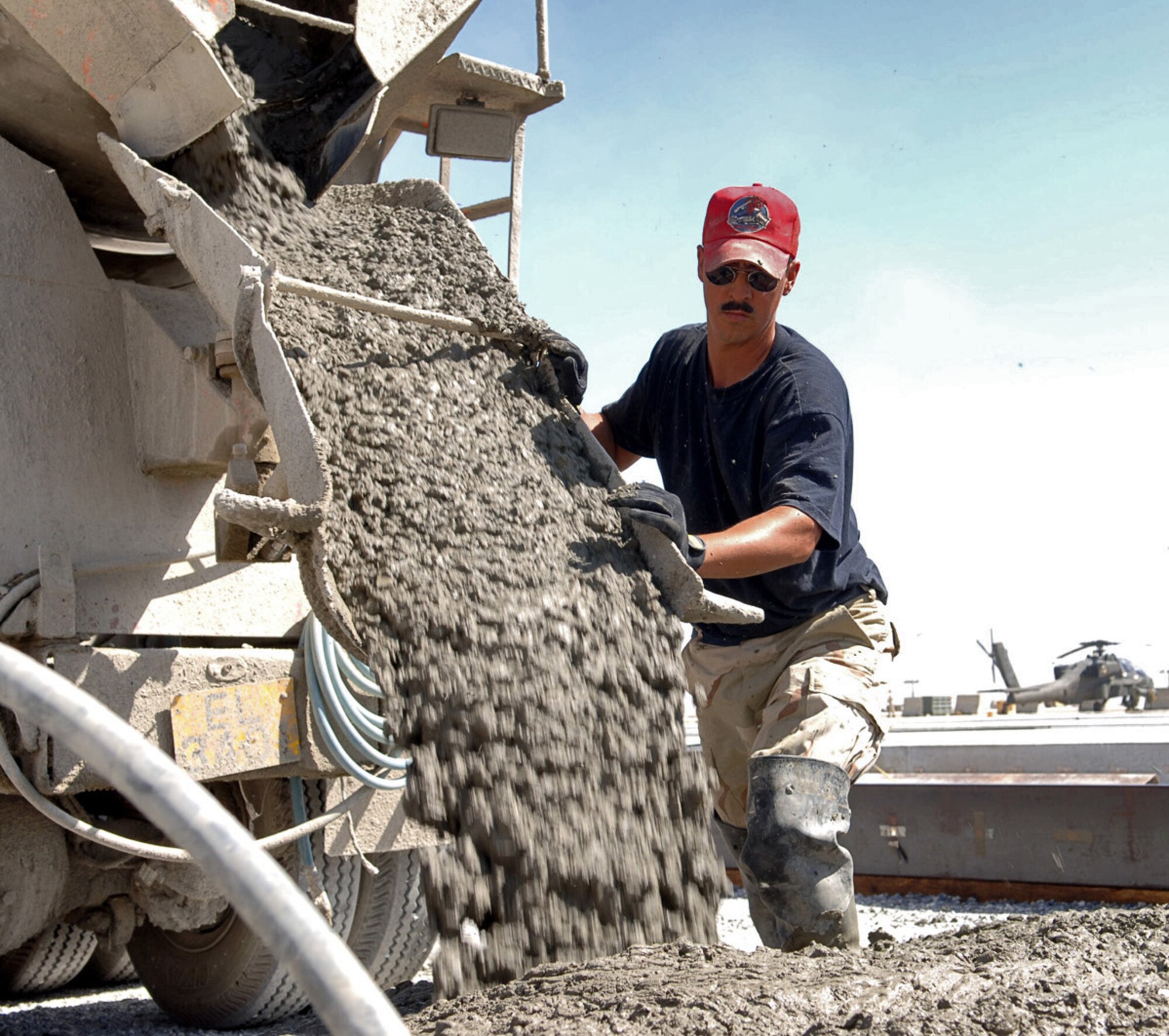 BAGRAM AIR BASE, Afghanistan -- Staff Sgt. Joel Kennedy directs concrete as it is poured onto the newest section of the aircraft parking ramp here. The 1st Expeditionary Red Horse Group from Nellis Air Force Base, Nev., is adding an additional 60,000 square meters of aircraft ramp space as part of a $4.4-million airfield upgrade project. Sergeant Kennedy is a pavement and equipment craftsman with the 1st ERHG. (U.S. Air Force photo by Capt. James H. Cunningham) 