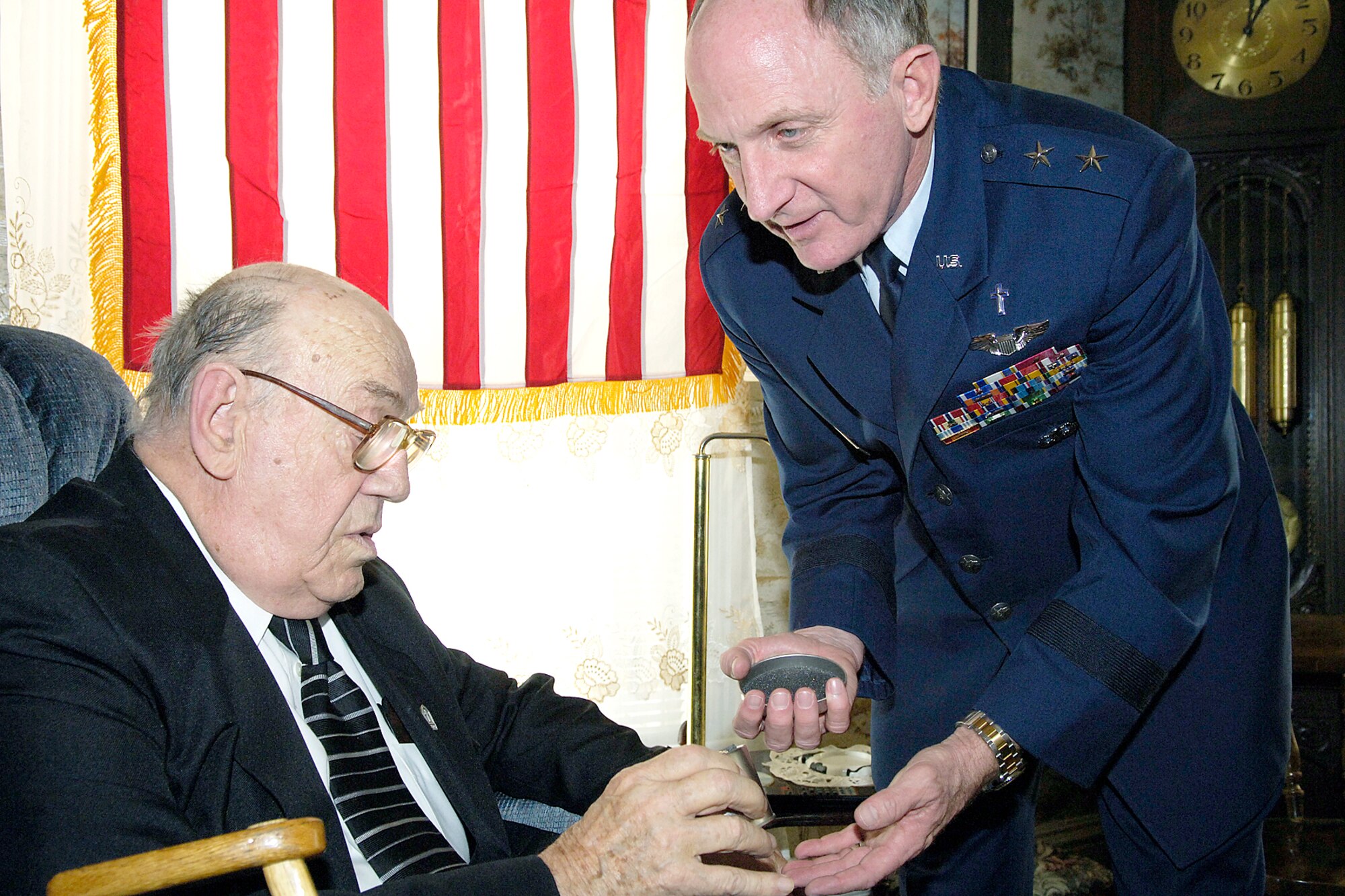 BREWER, Maine -- Chaplain (Maj. Gen.) Charles C. Baldwin (right) posthumously presents the Bronze Star to Staff Sgt. Merle Y. Strang on Sept. 27.  Accepting the medal on his brother's behalf is the Rev. Homer Strang.  Sergeant Strang was awarded the Bronze Star for his participation in the Korean War's Kiddie Car Airlift, where he was credited for saving the lives of 950 orphans and 100 orphanage staff members.  Chaplain Baldwin is the Air Force Chaplain Service chief.  (U.S. Air Force photo by Tech. Sgt. Michael Brogan)