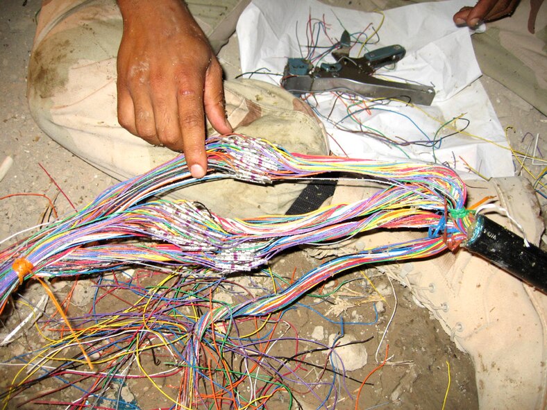 ALI BASE, Iraq -- Airmen with the 407th Expeditionary Communications Squadron had to match and connect 200 copper wires and six fiber cables to get the 407th Personnel Support fro Contingency Operations section's communications back online.  (U.S. Air Force photo by 1st Lt. Adam Pudenz) 
