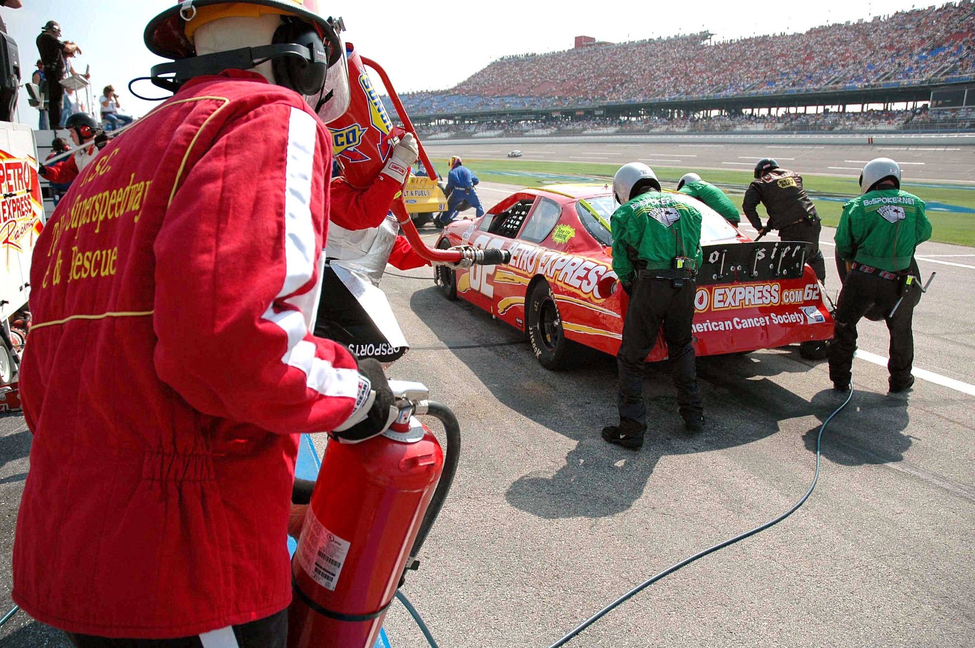 TALLADEGA, Ala. -- J.R. Sudarth watches over the Wood Brothers Racing Team as they conduct a 10-second pit stop on the No. 21 Air Force-sponsored NASCAR.  The care was recently driven by Ricky Rudd at the Talladega Superspeedway on Oct. 2.  Mr. Sudarth and three other firefighters from Eglin Air Force Base, Fla., were among a group of firefighters who work part-time each spring and fall at Talladega NASCAR races to make sure the drivers and race teams are safe.  (U.S. Air Force photo by Senior Airman Mike Meares)
