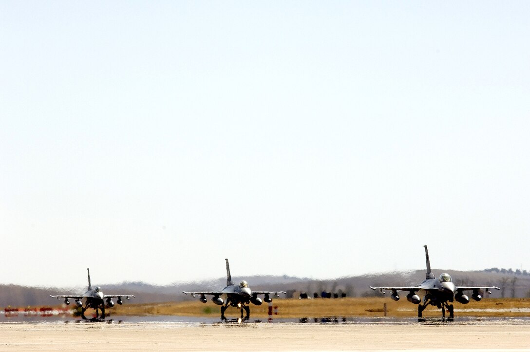 MORON AIR BASE, Spain -- F-16 Fighting Falcons taxi in for service and crew rest here.  The Air Force reservists from the 180th Fighter Wing at Toledo, Ohio, are on their way home after supporting Operation Iraqi Freedom.  The fighters are part of "Coronet East," a title given to a group of jet fighters flying with necessary tankers for air refueling and an air transport with necessary maintenance support in tow.  (U.S. Air Force photo by Master Sgt. John E. Lasky) 