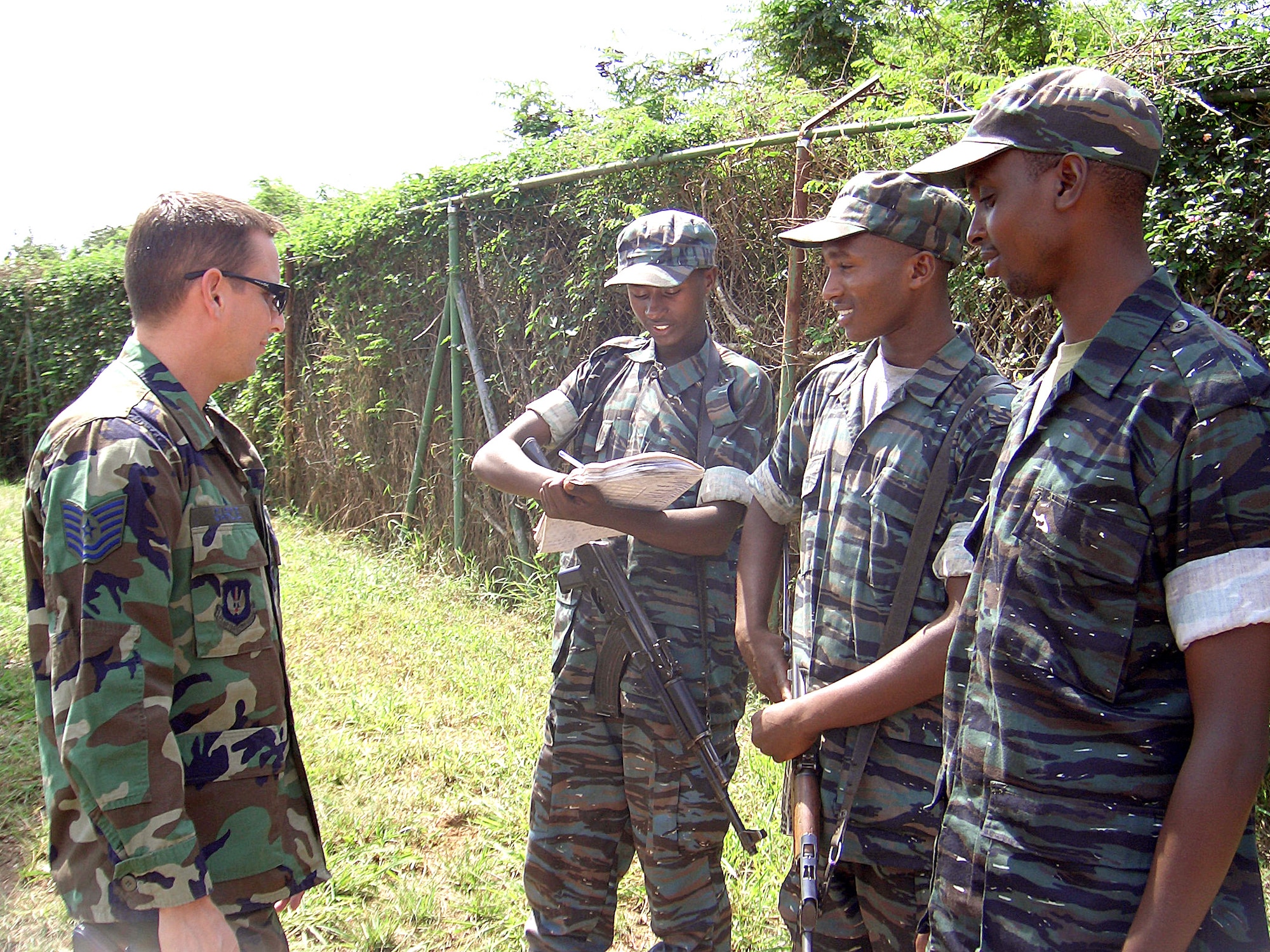KIGALI, Rwanda -- Tech. Sgt. Sean Garcie consults with Rwandan security forces troops about entry control procedures.  Airmen with the 786th Security Forces Squadron at Sembach Air Base, Germany, and 435th SFS at Ramstein AB, Germany, are protecting people and aircraft during the 86th Air Expeditionary Group's airlift mission here.  (U.S. Air Force photo by 1st Lt. Elizabeth Culbertson)