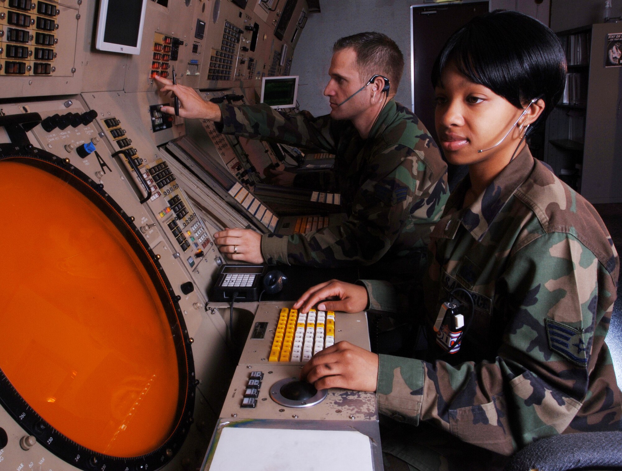 YOKOTA AIR BASE, Japan -- Staff Sgt. Carmen Jones (left) and Senior Airman David Winkfield use radarscopes to coordinate aircraft movement here.  The 374th Operations Support Squadron radar approach control technicians are responsible for military, general and commercial aviation aircraft that use eight separate airports which encompass 8,575 miles of airspace in the Tokyo area.  The Airmen keep planes at safe distances from each other, direct them during takeoff and landing from airports, direct them around bad weather and ensure that traffic flows smoothly with minimal delays.  (U.S. Air Force photo by Master Sgt. Val Gempis)