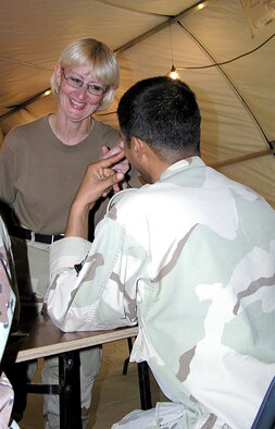 ALI BASE, Iraq -- Beverly Hall laughs with one of 15 Iraqi Airmen during her English class.  Mrs. Hall is part of a four-person Defense Language Institute mobile training team here.  (U.S. Air Force photo by Tech. Sgt. Paul Dean)

