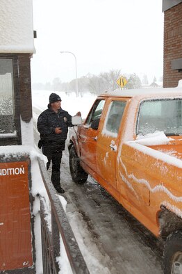 MINOT AIR FORCE BASE, N.D. -- Keith Anderson checks identification cards at the main gate here after the first snowfall of the year.  As of 11 a.m. on Oct. 5, the base had received 5 inches of snow to accompany 45-mph winds and a temperature of 32 degrees.  Mr. Anderson is a gate guard with the 5th Security Forces Squadron.  (U.S. Air Force photo by Airman Christopher Boitz)
