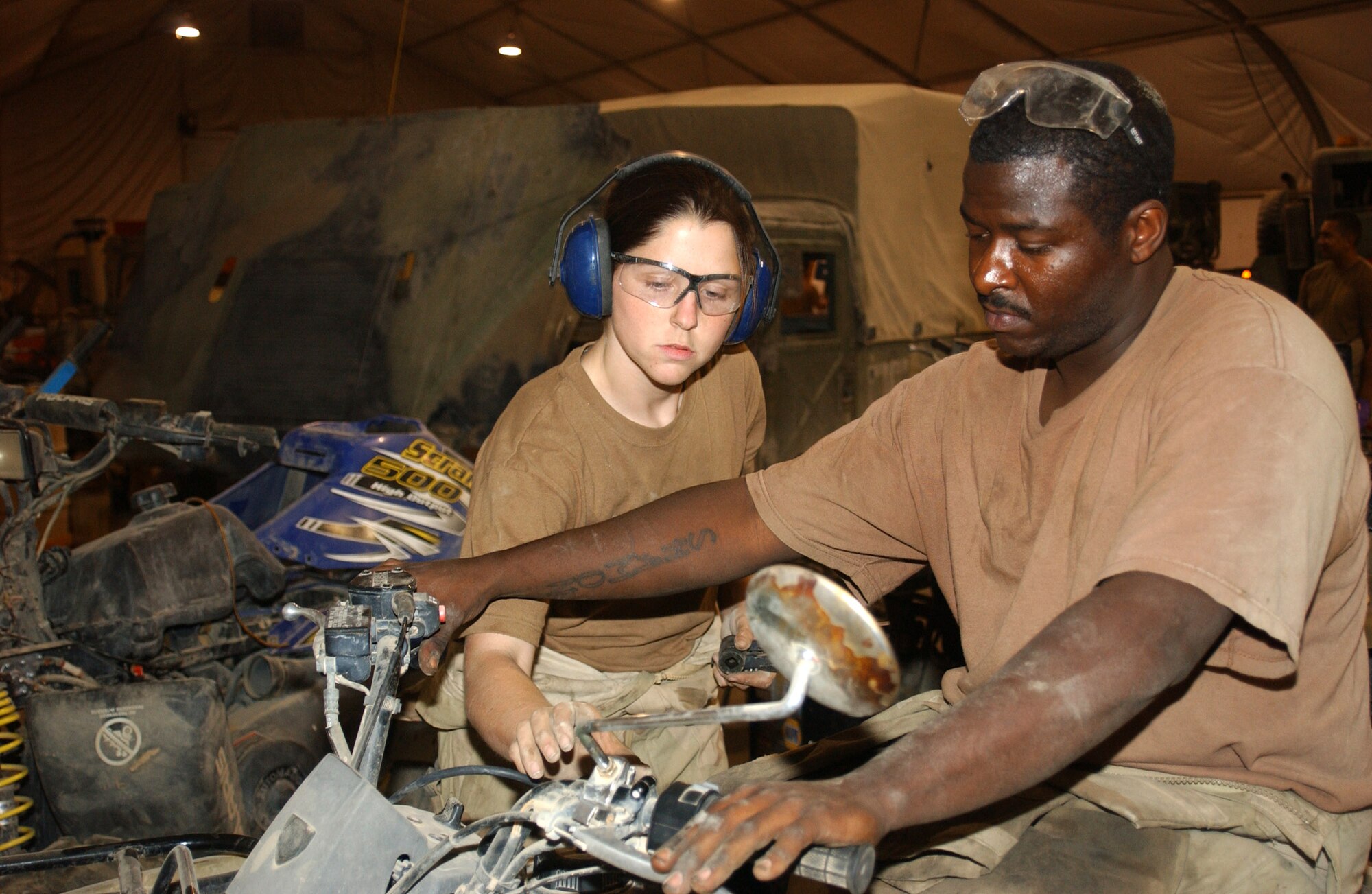 ALI BASE, Iraq -- Senior Airmen Lara Martin (left) and Dennis Maynard start up an all-terrain vehicle they repaired here.  The Airmen with the 407th Expeditionary Logistics Readiness Squadron's vehicle maintenance section here are able to fix any vehicle on base.  Airman Martin is deployed from Ramstein Air Base, Germany, and Airman Maynard is deployed from Pope Air Force Base, N.C.  (U.S. Air Force photo by Tech. Sgt. Paul Dean)