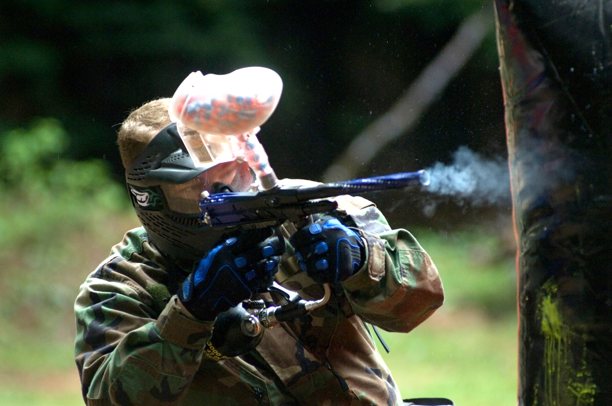 PULASKI BARRACKS, Germany -- Staff Sgt. Chris Matthews fires away during a paintball competition here.  Two three-person teams squared off against each other from opposite ends of an enclosed area with obstacles between them during a three-minute contest.  Fifteen American and German teams participated in the competition.  Sergeant Matthews is a jet engine mechanic with the 52nd Component Repair Squadron at Spangdahlem Air Base, Germany.  (U.S. Air Force photo by Master Sgt. John E. Lasky)