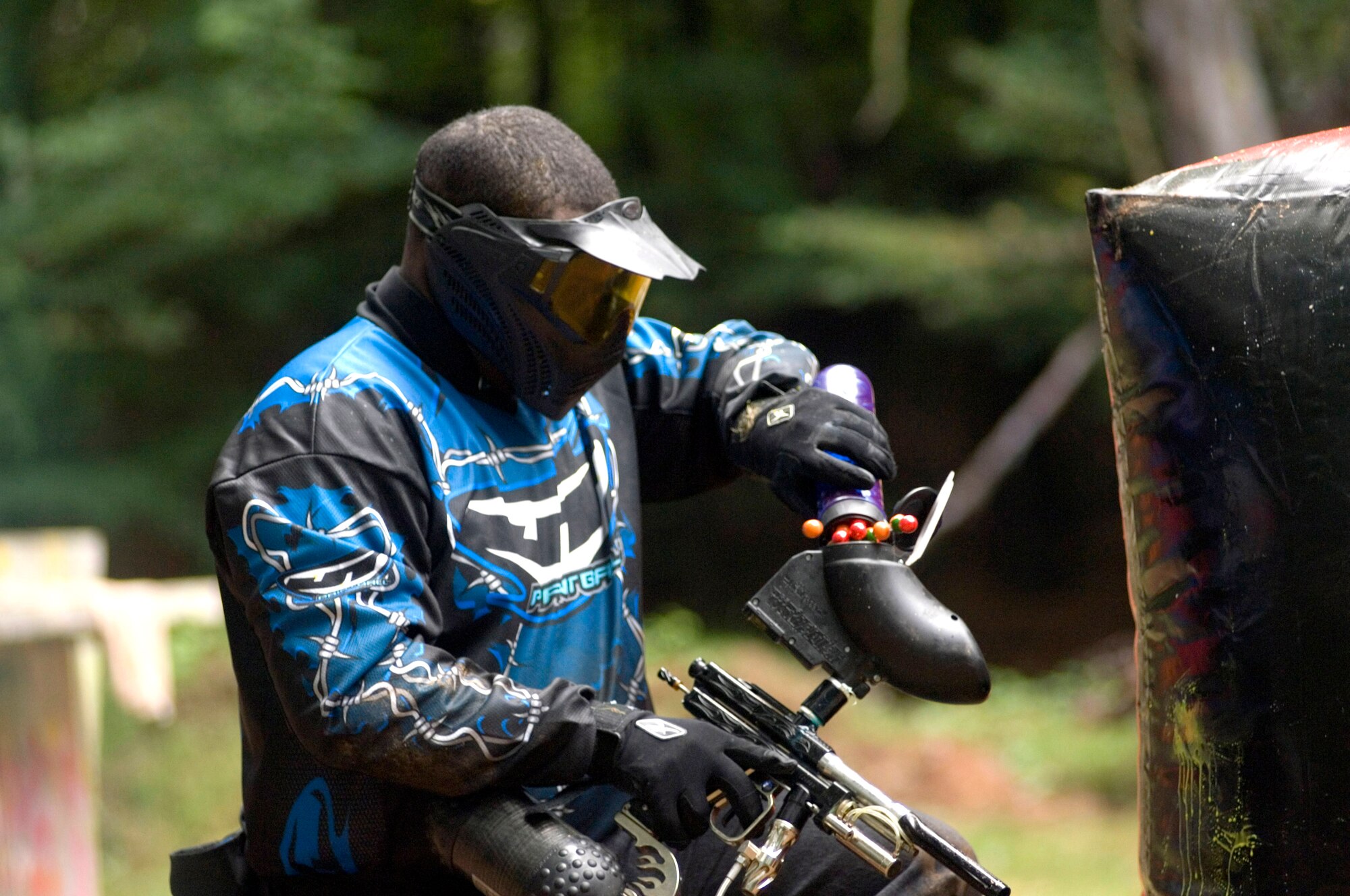 PULASKI BARRACKS, Germany -- Staff Sgt. Chris Matthews reloads paintballs during a competition here.  Two three-person teams squared off against each other from opposite ends of an enclosed area with obstacles between them during a three-minute contest.  Fifteen American and German teams participated in the competition.  Sergeant Matthews is a jet engine mechanic with the 52nd Component Repair Squadron at Spangdahlem Air Base, Germany.  (U.S. Air Force photo by Master Sgt. John E. Lasky)
