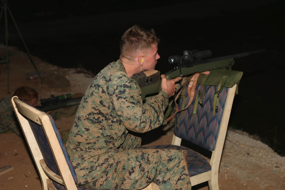 Lance Cpl. Nick Peel, rifleman, 1st Battalion, 3rd Marine Regiment, uses two chairs for stability during the Scout Sniper Basic Courses position-shooting training at Schofield Barracks, Friday. This training is to better prepare Marines to use anything they can find in order to make a better shot.