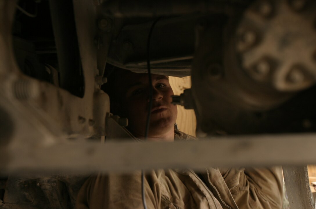 Lance Cpl. Charlie S. Holcomb makes repairs Oct. 11 on a HUMVEE that received damage due to an improvised explosive attack. Holcomb is a 21-year-old native of Elmwood, WI, and a motor transportation mechanic assigned to Maintenance Company, Combat Logistics Battalion-8, 2nd Force Service Support Group (Forward) in Fallujah, Iraq.