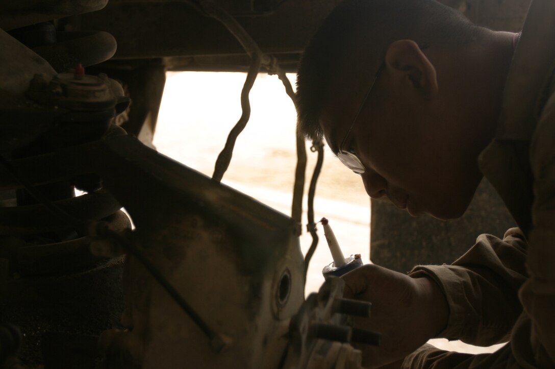 Lance Cpl. Albert Siu makes repairs Oct. 11 on a HUMVEE that received damage due to an improvised explosive attack. Siu is a 20-year-old native of Atlantic City, NJ, and a motor transportation mechanic assigned to Maintenance Company, Combat Logistics Battalion-8, 2nd Force Service Support Group (Forward) in Fallujah, Iraq.