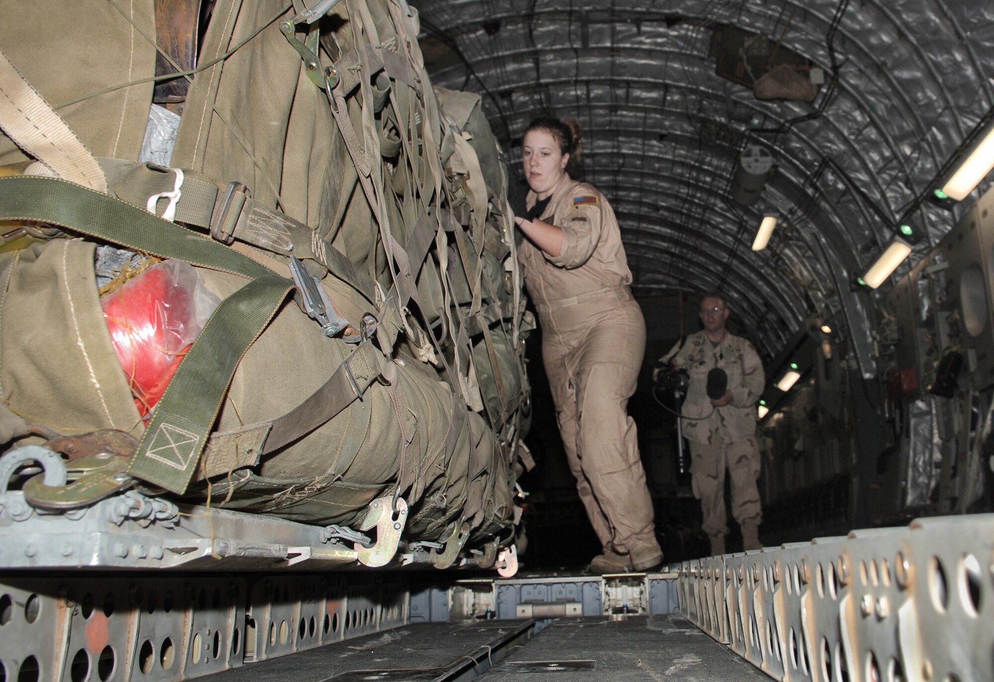 ISLAMABAD, Pakistan -- Airman 1st Class Marie Gamachie, a C-17 Globemaster III loadmaster, unloads a pallet of the first relief supplies from the United States here Oct. 9 less than 48 hours after the devastating earthquake that left thousands dead and thousands more injured. The cargo comprised 12 pallets of food, water, medicine and blankets and weighed almost 90,000 pounds. Two aerial port specialists from the 455th Expeditionary Logistics Readiness Squadron at Bagram Air Base, Afghanistan, were also on the flight to coordinate and manage cargo. The C-17 and its crew are from the 7th Airlift Squadron at McChord Air Force Base, Wash. (U.S. Air Force photo by Capt. James H. Cunningham)