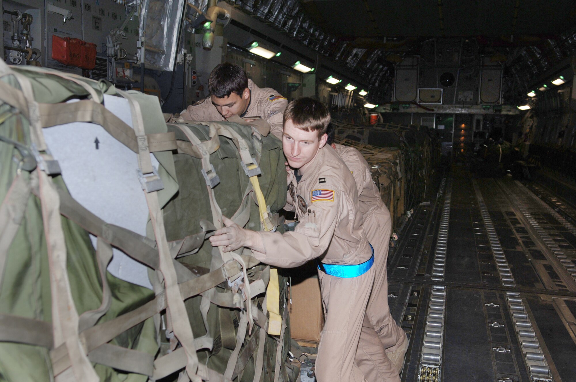 ISLAMABAD, Pakistan -- Capt. Todd Stinchfield, C-17 Globemaster III aircraft commander, helps unload a pallet of the first relief supplies from the United States here Oct. 9 less than 48 hours after the devastating earthquake that left thousands dead and thousands more injured. The cargo comprised 12 pallets of food, water, medicine and blankets and weighed almost 90,000 pounds. Two aerial port specialists from the 455th Expeditionary Logistics Readiness Squadron at Bagram Air Base, Afghanistan, were also on the flight to coordinate and manage cargo. The C-17 and its crew are from the 7th Airlift Squadron at McChord Air Force Base, Wash. (U.S. Air Force photo by Capt. James H. Cunningham)