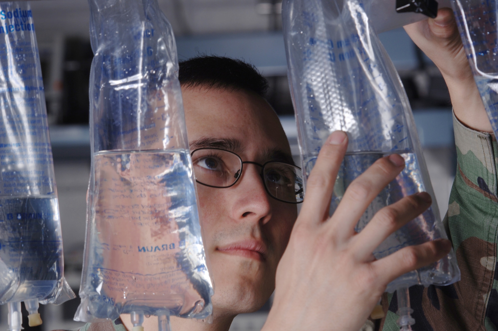 YOKOTA AIR BASE, Japan -- Airman 1st Class Thomas Elliott fills intravaneous bags with water while conducting a calibration and verification test on an infusion pump. The test ensures the equipment properly administers fluid to patients here. He is a biomedical equipment technician with the 374th Medical Support Squadron's medical equipment repair center.  (U.S. Air Force photo by Master Sgt. Val Gempis)