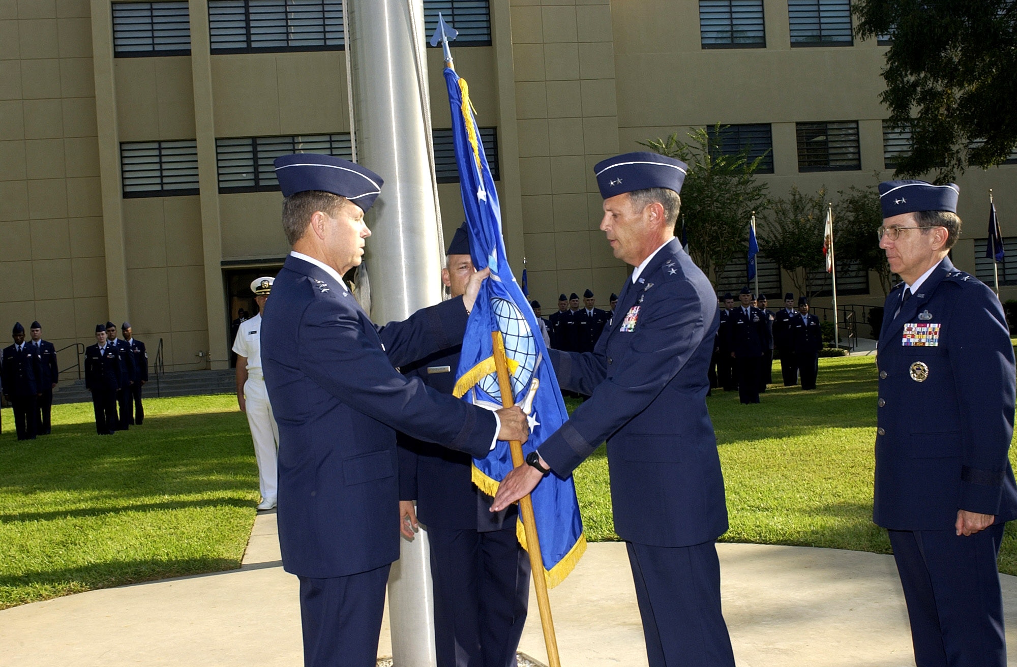 LACKLAND AIR FORCE BASE, Texas -- Maj. Gen. John C. Koziol (second from right) receives the Air Intelligence Agency guidon from Lt. Gen. William M. Fraser III, vice commander of Air Combat Command, while Maj. Gen. Paul J. Lebras (right) and Chief Master Sgt. Edward Colquhoun Jr., AIA command chief master sergeant (center rear) observes.  (U.S. Air Force photo by Theodore Koniares)