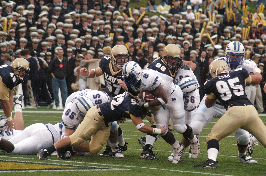 ANNAPOLIS, Md. -- Falcon fullback Jacobe Kendrick pushes his way forward for extra yardage after being wrapped up by Navy linebacker Jake Biles. Navy defeated Air Force 27-24. (U.S. Air Force photo by Tech. Sgt. Roy Utley)