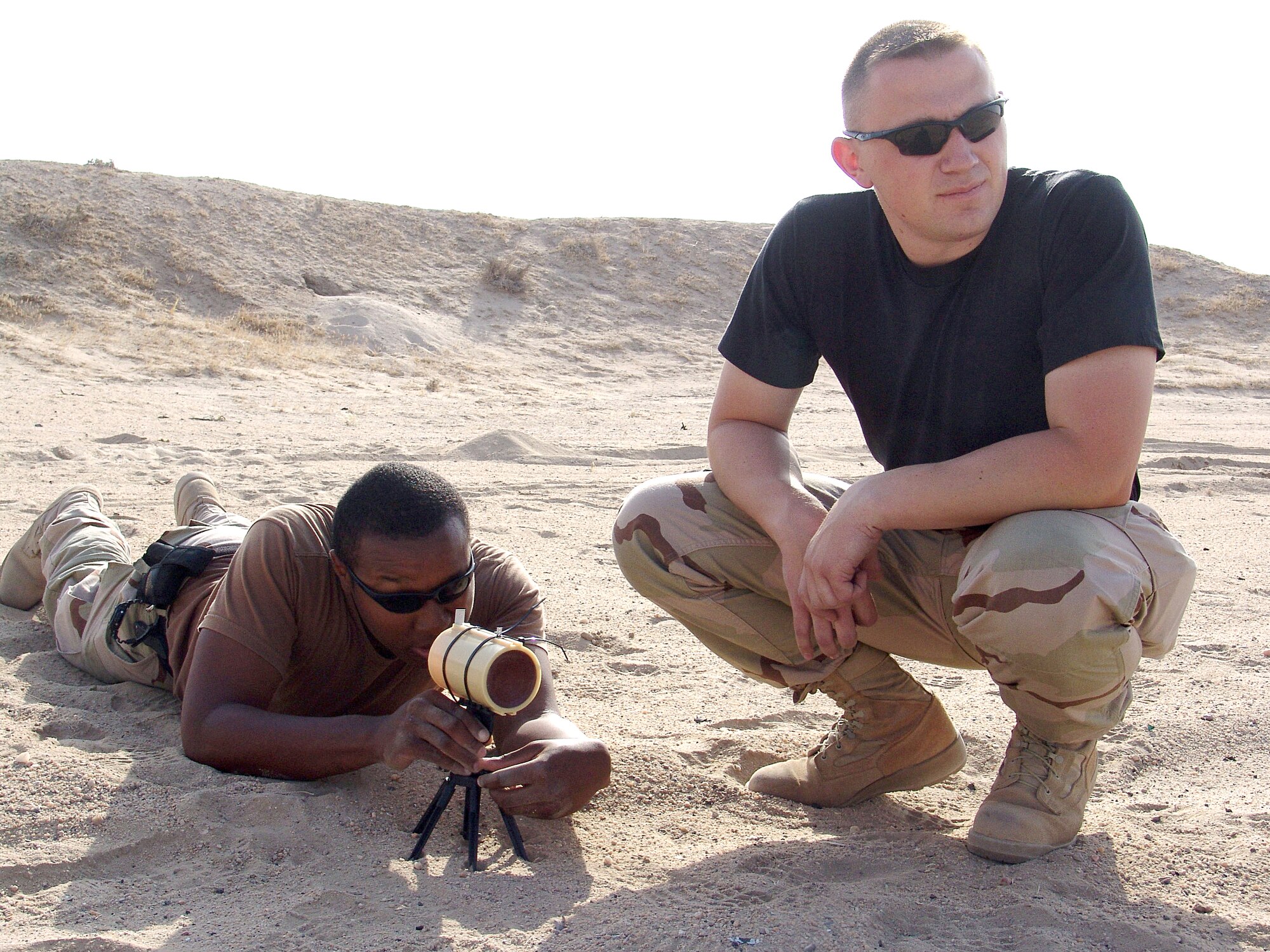 SOUTHWEST ASIA -- Staff Sgt. Monty Woolam and Senior Airman Keith Green sight in a mark 24 for disposing of explosives. Sergeant Woolam and Airman Green are assigned to the 386th Expeditionary Civil Engineer Squadron's explosive ordnance disposal unit and are deployed from Elmendorf Air Force Base, Alaska. (U.S. Air Force photo by Senior Airman Michael A. Garza)