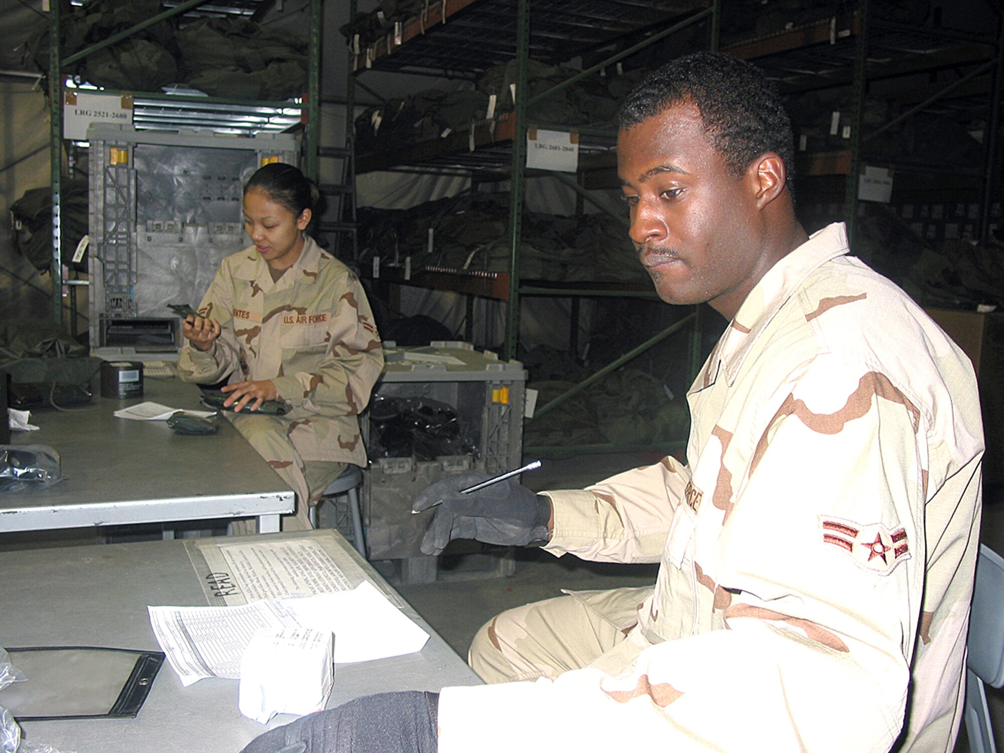 MANAS AIR BASE, Kyrgyzstan - (From left) Airman 1st Class Kathrine Fuentes and Airman 1st Class DeMarcus Mason inventory equipment before rebuilding a mobility bag here. The Airmen are assigned to the 376th Expesitionary Logistics Readiness Squadron. (U.S. Air Force photo)
