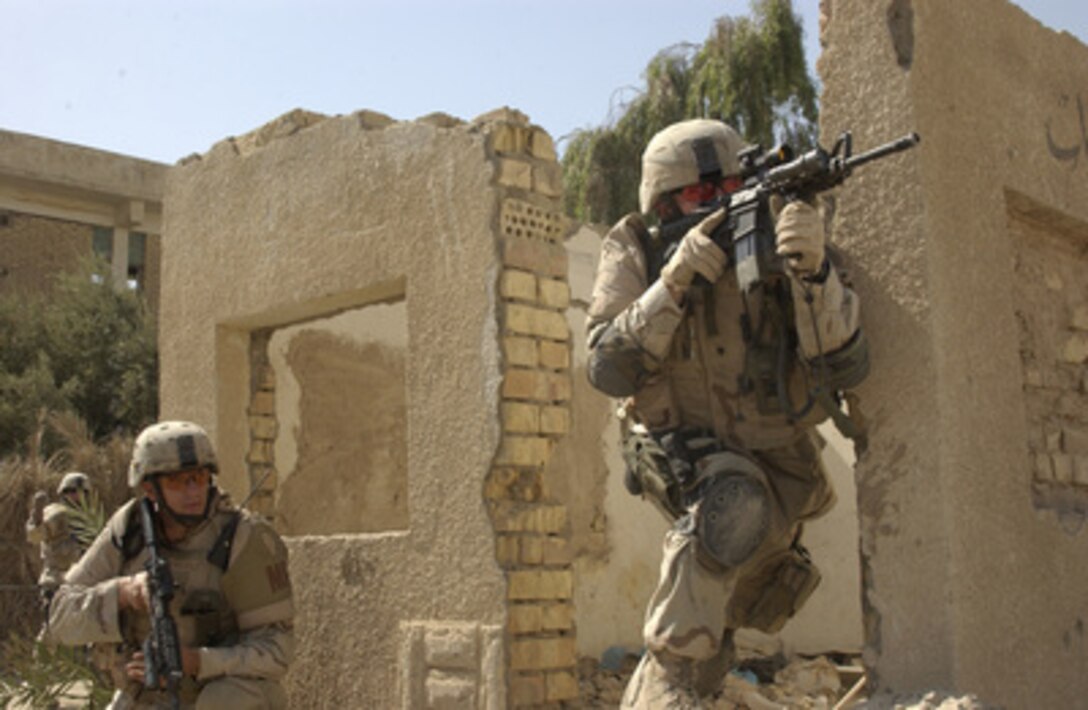 U.S. Army soldiers with Alpha Company, 1st Battalion react to small arms fire while searching for weapons caches in Al Madain, Baghdad, Iraq, on Sept. 20, 2005. 