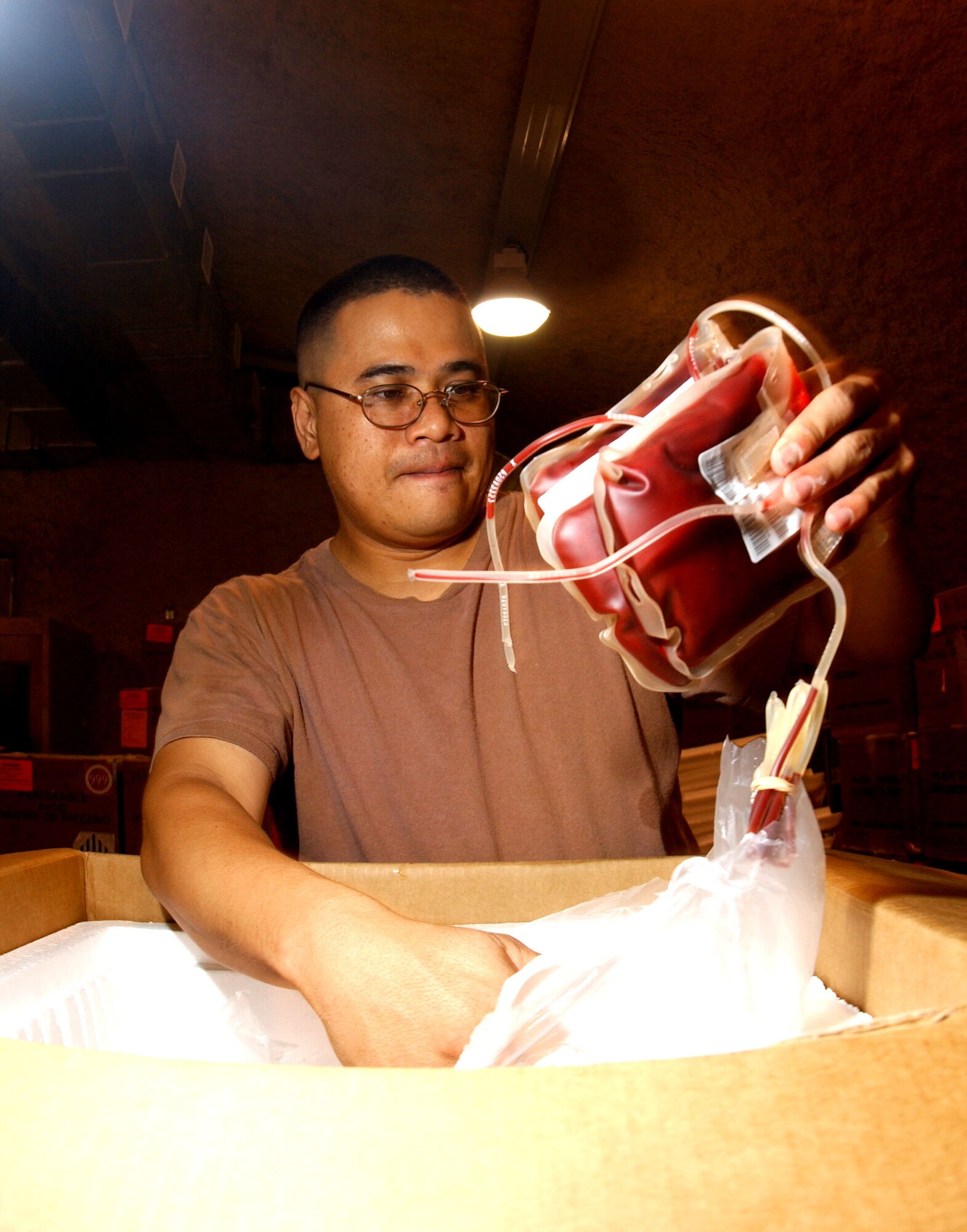 SOUTHWEST ASIA -- Tech. Sgt. Octavio Suarez unpacks blood that will be used to help care for injured troops in Iraq and Afghanistan. The sergeant, with the 379th Expedionary Medical Group, deployed here from the 355th Medical Group Davis-Monthan Air Force Base, Ariz. (U.S. Air Force photo by Airman 1st Class De-Juan Haley)