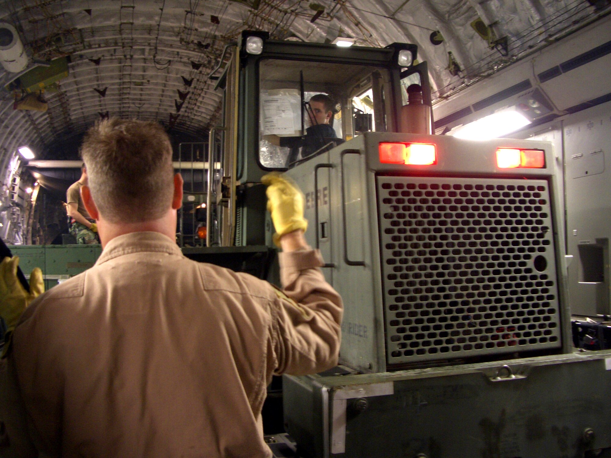 MCGUIRE AIR FORCE BASE, N.J. -- Staff Sgt. Terry Owens helps Senior Airman Drew Dentinger loads a 10K all-terrain forklift onto a C-17 Globemaster III. On Oct. 10, the aircraft left here to deliver 52.4 tons of support equipment to Pakistan in response to earthquake relief operations. The aircraft was one of two C-17s that flew 45 members of the 621st Contingency Response Wing to the country. Both Airmen are with the 305th Aerial Port Squadron here. (U.S. Air Force photo by Senior Airman Dilia DeGrego)