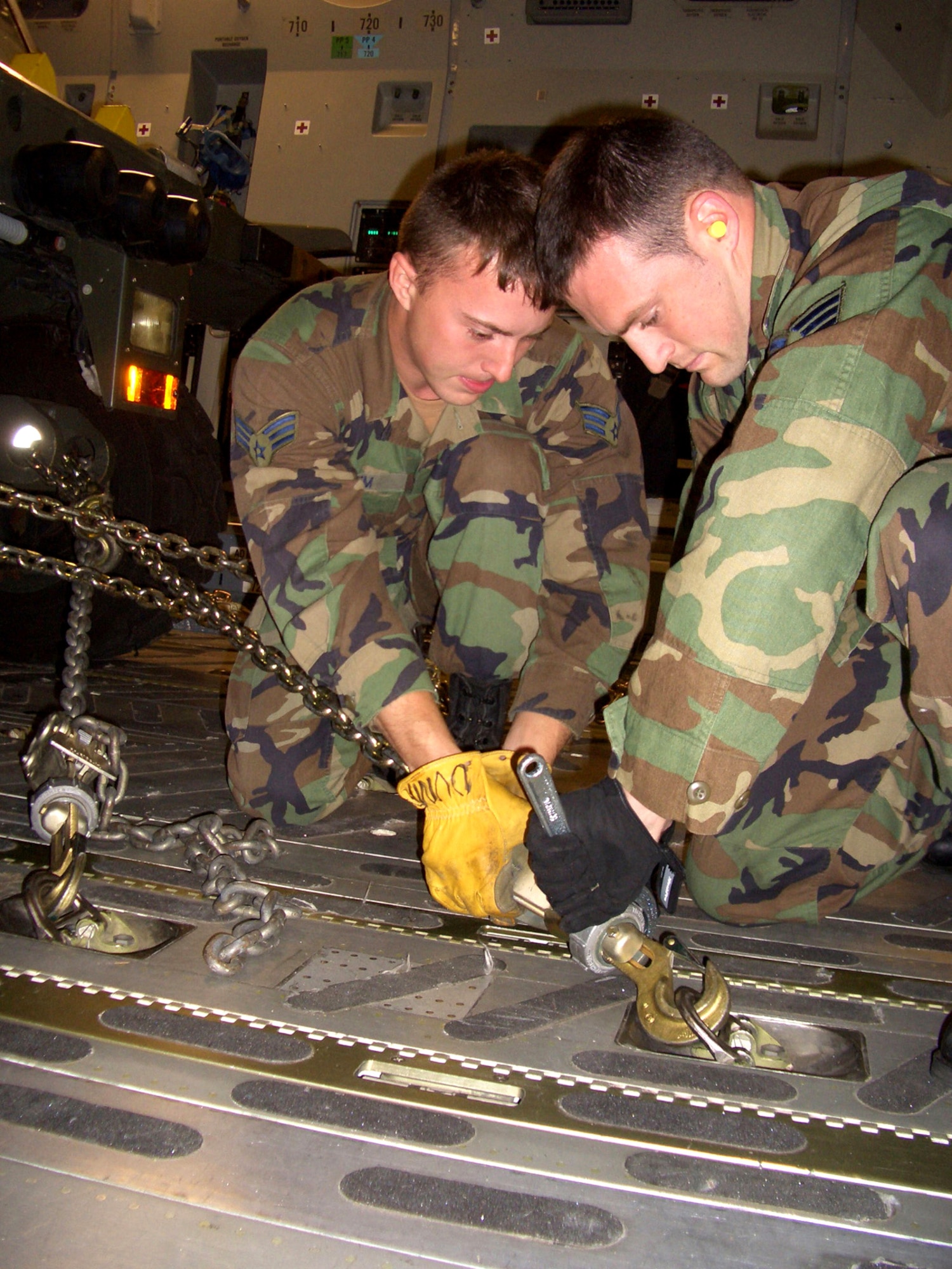 MCGUIRE AIR FORCE BASE, N.J. -- Senior Airmen Regis Dumm and Clint Kubach tie and secure a vehicle to the floor of a C-17 Globemaster III bound for Pakistan. The aircraft, loaded with relief supplies and members of the 621st Contingency Response Wing, left here Oct. 10. Both Airmen are assigned to the 305th Aerial Port Squadron here. (U.S. Air Force photo by Senior Airman Dilia DeGrego)
