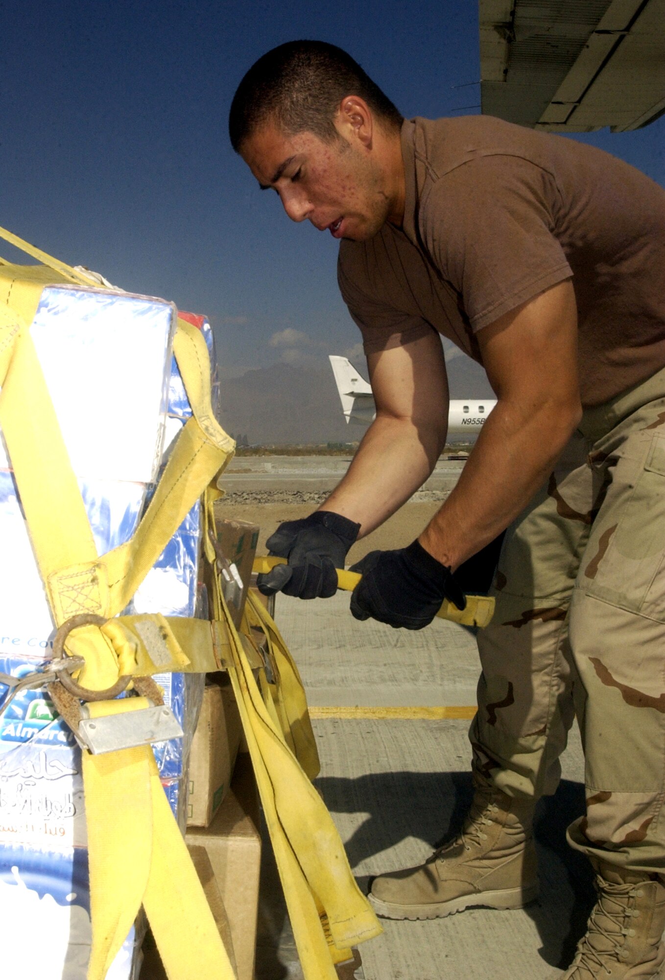 BAGRAM AIR BASE, Afghanistan -- Airman 1st Class Gregory Viruet secures a pallet of cargo of earthquake relief supplies bound for Pakistan. The first relief supplies from the United States were ready for departure aboard a C-17 Globemaster III here less than 48 hours after the devastating earthquake left thousands dead and thousands more injured. More than 134,000 pounds of food, water, cots, medical supplies and American Red Cross items have been flown out of Bagram headed for Pakistan.  Airman Viruet is a short takeoff and landing coordinator with the 455th Expeditionary Logistics Readiness Squadron.  He is deployed from McChord Air Force Base, Wash.  (U.S. Air Force photo by Staff Sgt. Marcus McDonald)