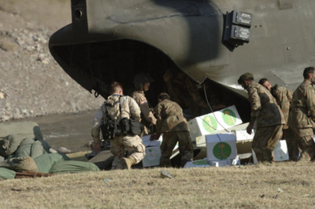 U.S. Army CH-47 Chinook helicopter crewmen and Pakistani military members unload relief supplies in a remote town in Northern Pakistan on Oct. 12, 2005. The Department of Defense is supporting the State Department by providing disaster relief supplies and services following the massive earthquake that struck Pakistan and parts of India and Afghanistan. 