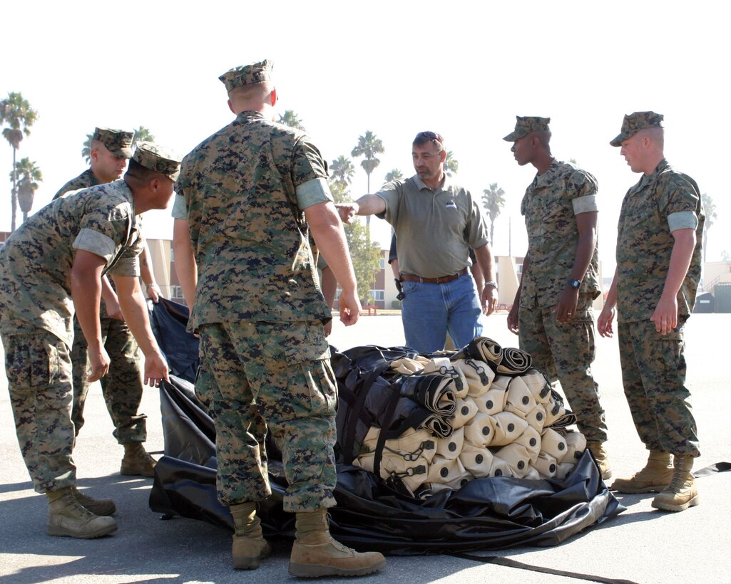CAMP PENDLETON, Calif. (Oct. 13, 2005) -- Ron Vasher, center, western region representative for Base-X Expedition Shelters, directs Marines from the 15th Marine Expeditionary Unit as they learn to set up a Base-X shelter tent at Camp Del Mar. Marines from the 15th MEU are practicing assembling and disbanding the new tent to become more expedient during combat operations. (Official USMC photo by Cpl. Thomas J. Grove)