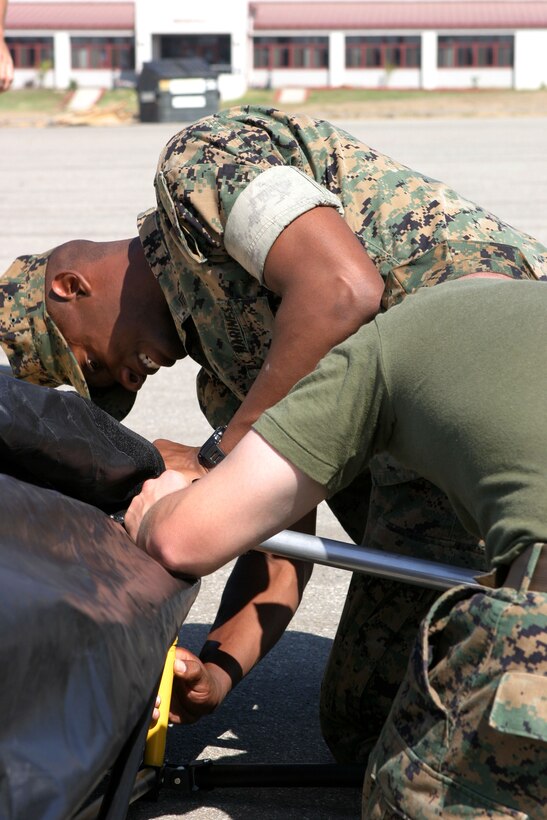 Sgt. Ricardo J. Sherman, centered, an intelligence anaylist with the 15th Marine Expeditionary Unit and native of Detriot, helps Lance Cpl. George E. Gifford, a network specialist and native of Kite, Ga., take down a Base-X shelter tent at Camp Del Mar here. Marines from the 15th MEU are practicing assembling and disbanding the new tent to become more expedient during combat operations.