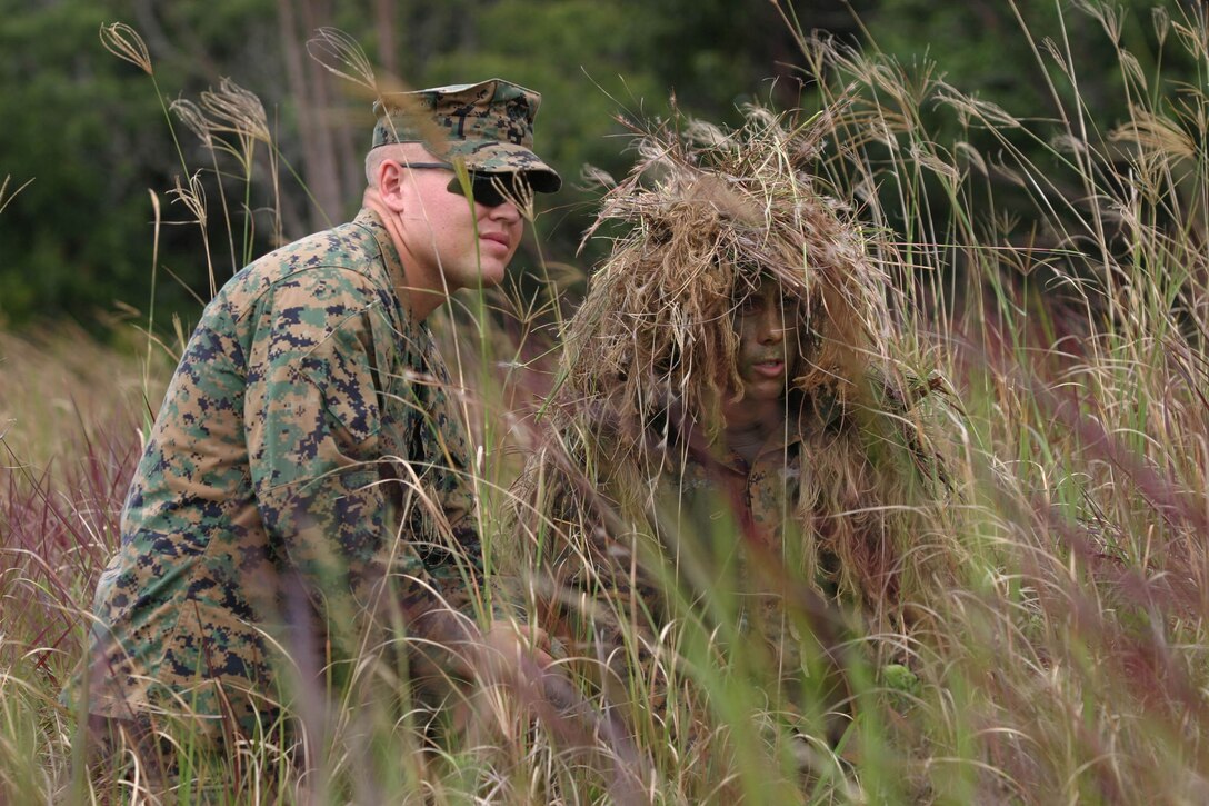 Sgt, Andrew Jones (left), instructor, Scout Sniper Basic Course, assists a student during the stalking portion of the 10-week long training at Schofield Barracks, Oct. 13.