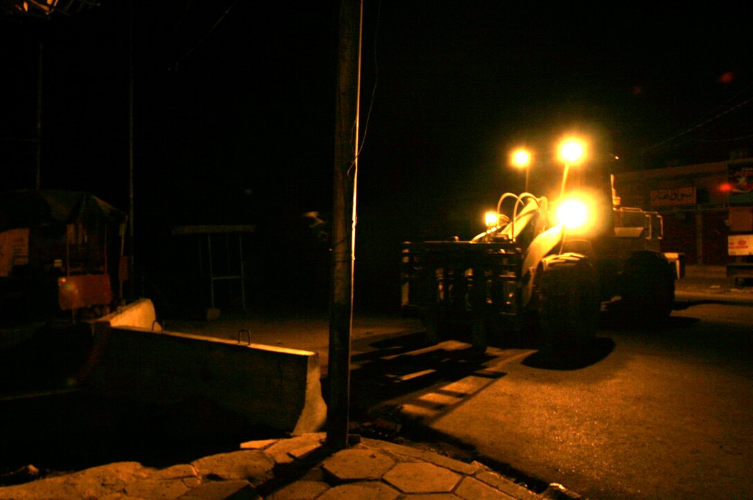 FALLUJAH, Iraq -- A forklift moves a concrete barrier into place in preparation for Iraq’s Oct. 15 vote on their constitutional referendum. Marines assigned to Transportation Support Company, Combat Logistics Battalion 8, 2nd Force Service Support Group (Forward), worked under the cover of darkness in order to help provide secure polling sites for tomorrow’s voters in the city of Fullujah. (Official Marine Corps photo by Sgt. Josh H. Hauser)(Released)