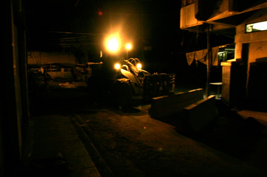 FALLUJAH, Iraq -- A forklift moves a concrete barrier into place in preparation for Iraq’s Oct. 15 vote on their constitutional referendum. Marines assigned to Transportation Support Company, Combat Logistics Battalion 8, 2nd Force Service Support Group (Forward), worked under the cover of darkness in order to help provide secure polling sites for tomorrow’s voters in the city of Fullujah. (Official Marine Corps photo by Sgt. Josh H. Hauser)(Released)