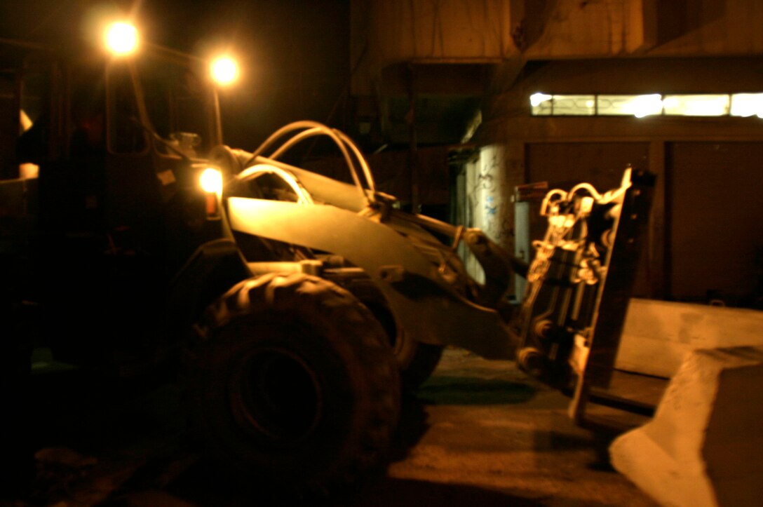 FALLUJAH, Iraq -- A forklift moves a concrete barrier into place in preparation for Iraq’s Oct. 15 vote on their constitutional referendum. Marines assigned to Transportation Support Company, Combat Logistics Battalion 8, 2nd Force Service Support Group (Forward), worked under the cover of darkness in order to help provide secure polling sites for tomorrow’s voters in the city of Fullujah. (Official Marine Corps photo by Sgt. Josh H. Hauser)(Released)