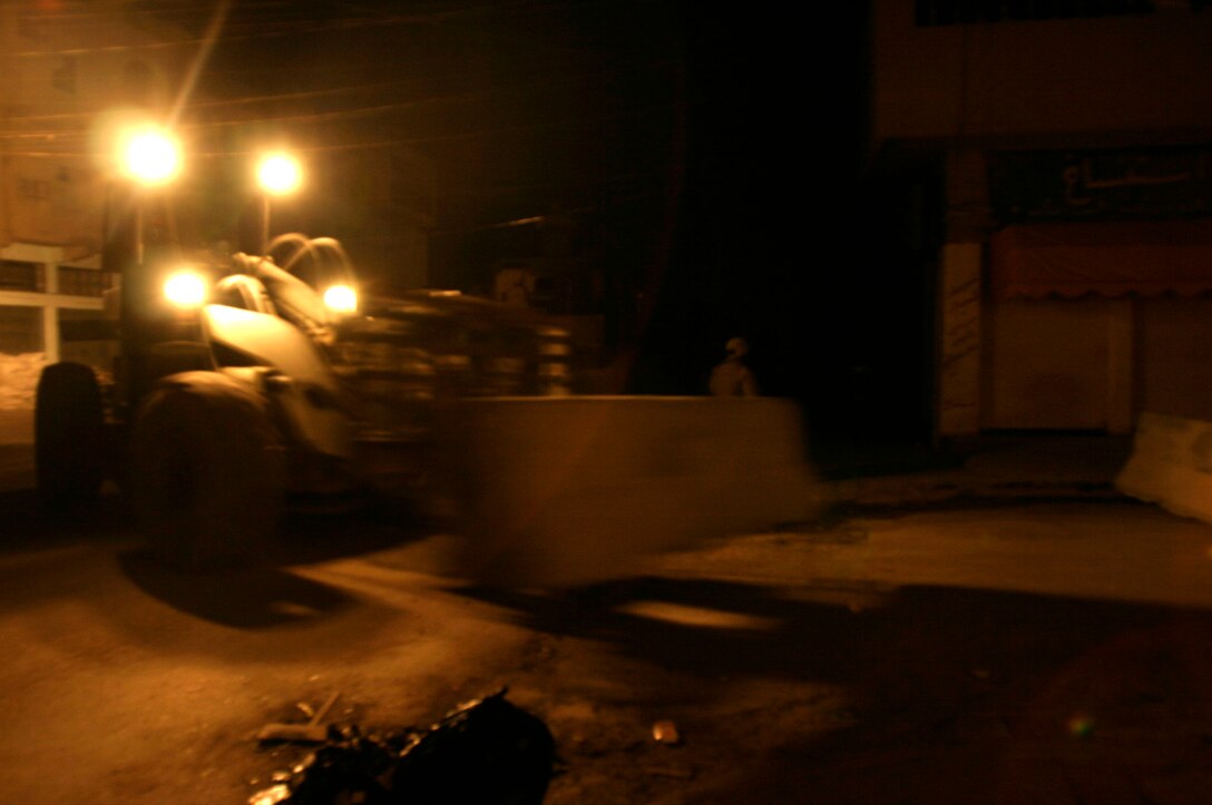 FALLUJAH, Iraq -- A forklift moves a concrete barrier into place in preparation for Iraq’s Oct. 15 vote on their constitutional referendum. Marines assigned to Transportation Support Company, Combat Logistics Battalion 8, 2nd Force Service Support Group (Forward), worked under the cover of darkness in order to help provide secure polling sites for tomorrow’s voters in the city of Fullujah. (Official Marine Corps photo by Sgt. Josh H. Hauser)(Released)