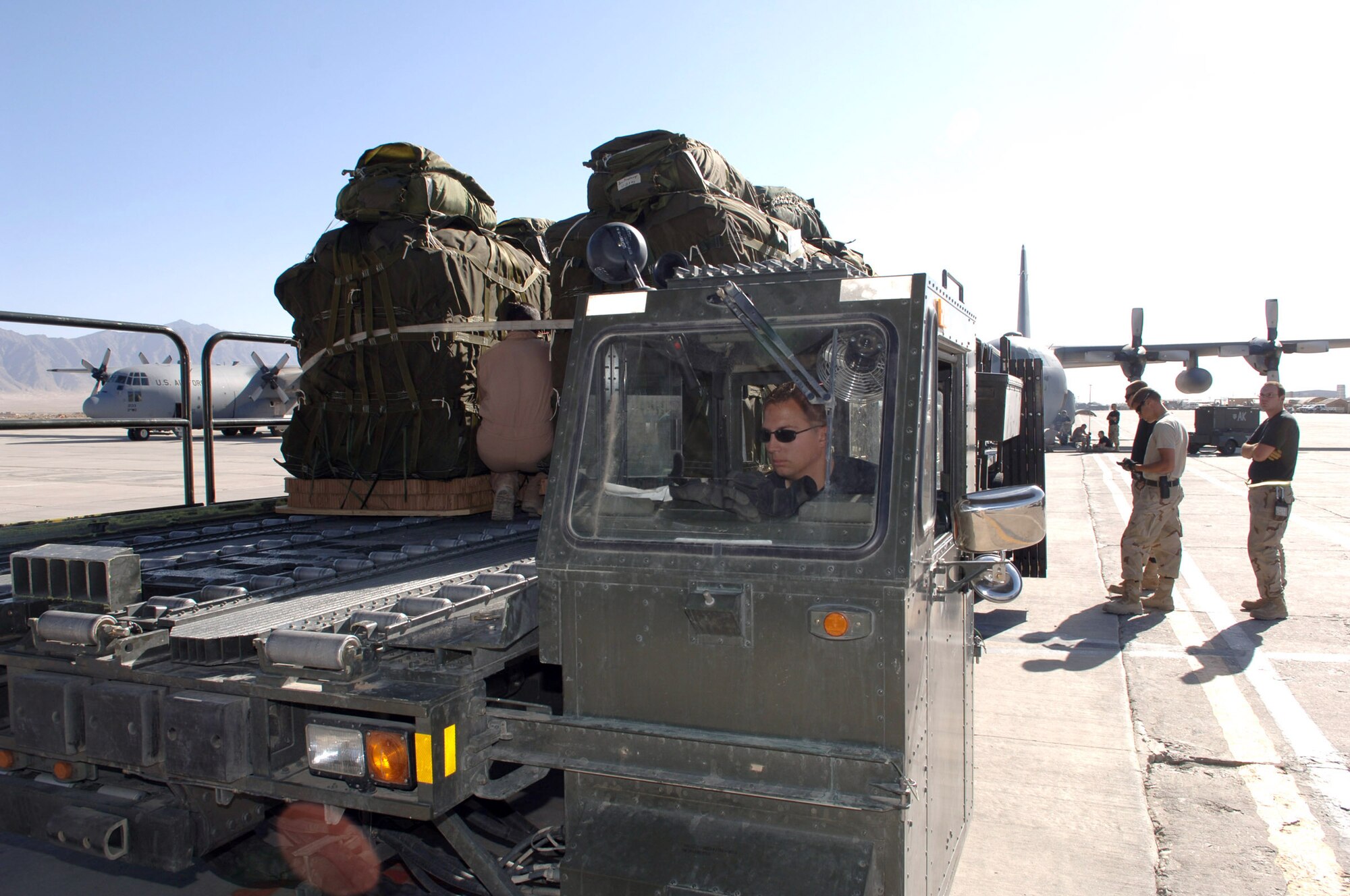 BAGRAM AIR BASE, Afghanistan - Staff Sgt. Tristan Schinzel, a ramp supervisor, maneuvers a 60-K loader into position to upload the first air drop supplies destined for Pakistan. The 14 pallets were the first to be air dropped into Pakistan. Soldiers and Airmen here assemble approximately 20,000 pounds of food, blankets, and supplies for the drop. To date, more than 180,000 pounds of food, water, cots and medical supplies have been flown out of Bagram headed for Pakistan. The sergeant, with the 455th Expeditionary Logistics Readiness Squadron here, is deployed from McChord Air Force Base, Wash. (U.S. Air Force photo by Capt. James H. Cunningham)