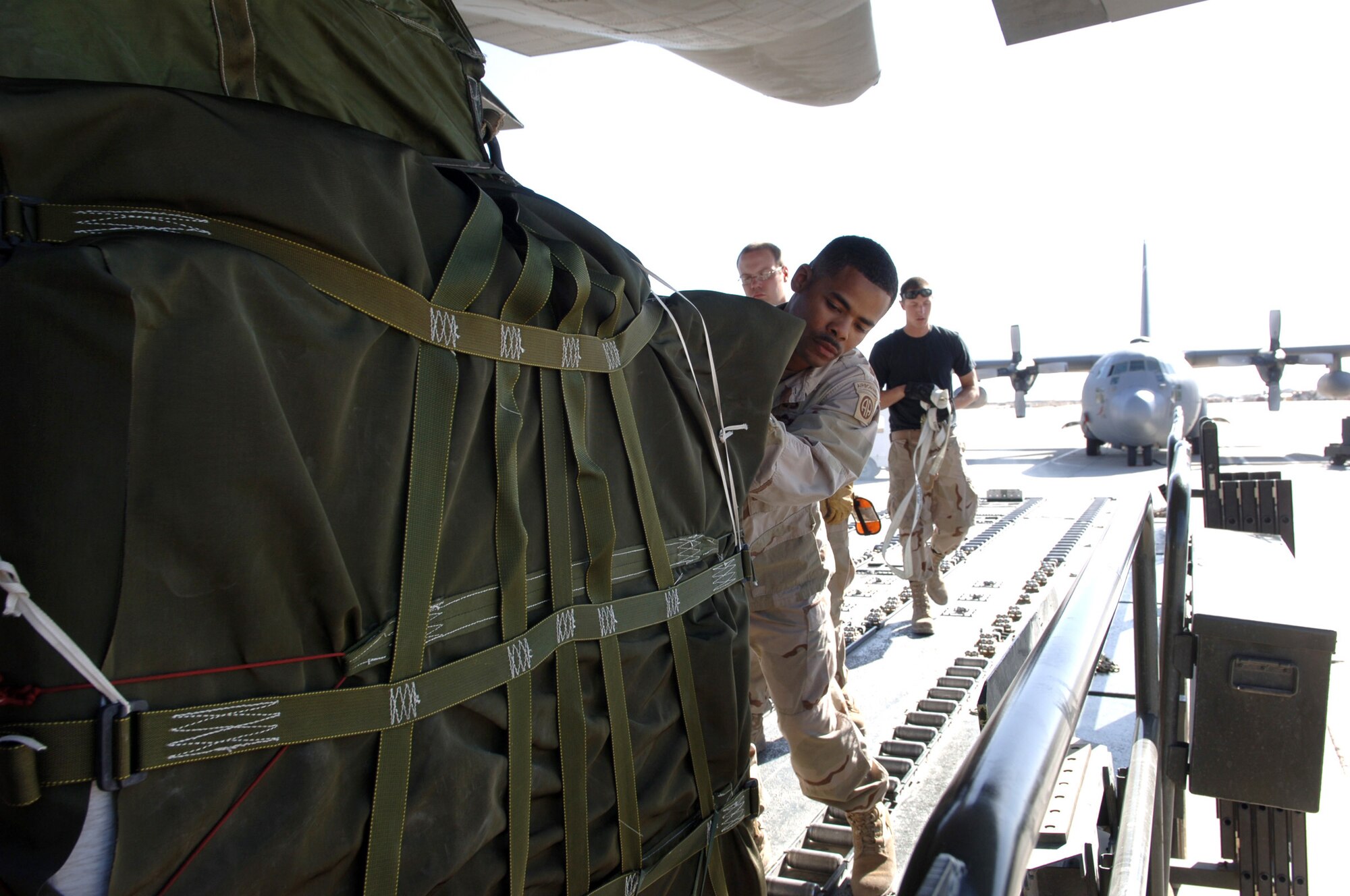 BAGRAM AIR BASE, Afghanistan - Army Sgt. Lamarr Haines, an 82nd Airborne Division parachute rigger, helps load a C-130 Hercules from the 517th Airlift Squadron with relief supplies destined for Pakistan. Troops loaded 14 pallets for the drop. Soldiers and Airmen here assemble approximately 20,000 pounds of food, blankets, and supplies for the drop. To date, more than 180,000 pounds of food, water, cots and medical supplies have been flown out of Bagram headed for Pakistan.  (U.S. Air Force photo by Capt. James H. Cunningham)