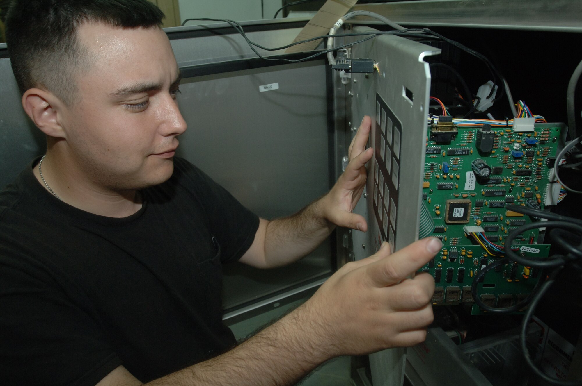 ALI AIR BASE, Iraq -- Senior Airman Leonard Reynolds reconnects and tests the transmitter receiver module on the base "giant voice," which ensures the command post has a reliable warning signal for base members. The Airman, a radio ground maintenance troop with the 407th Expeditionary Communications Squadron, did his check Oct. 13. He is deployed here from the 97th Communications Squadron, Altus Air Force Base, Okla. (U.S. Air Force photo by Senior Airman Jennifer Haas)