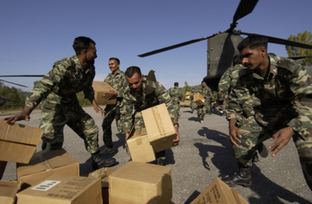 Pakistani soldiers hustle to unload U.S. medical supplies from a U.S. Army CH-47 Chinook helicopter in Islamabad, Pakistan, on Oct. 14, 2005. The Department of Defense is supporting the State Department by providing disaster relief supplies and services following the massive earthquake that struck Pakistan and parts of India and Afghanistan. 