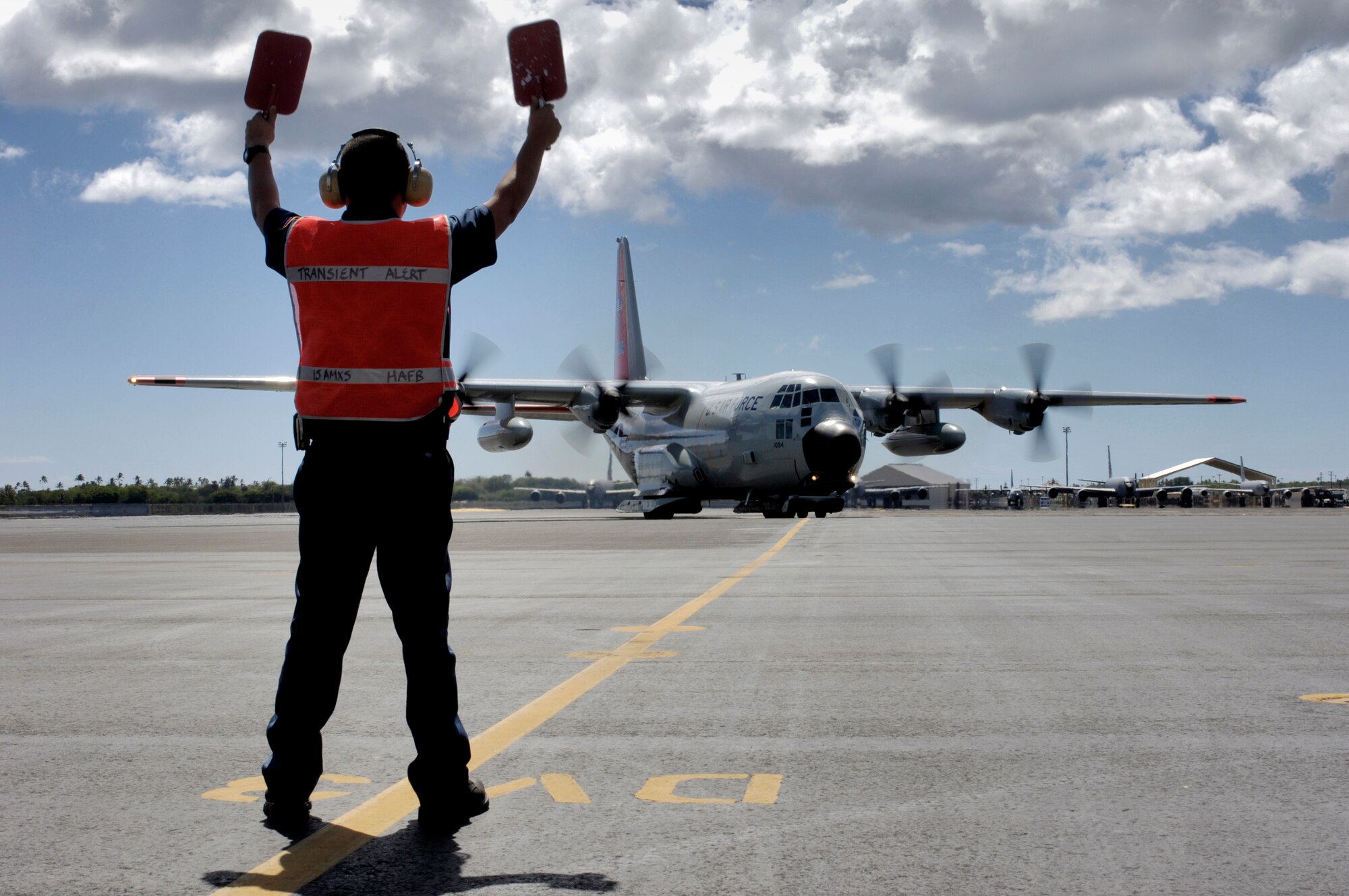 HICKAM AIR FORCE BASE, Hawaii -- Phil Rhodes, marshals an LC-130 Hercules from the New York Air National Guard's 109th Airlift Wing to a parking space here. Through Operation Deep Freeze, the wing ensures scientists near the South Pole have the people and supplies they need to do research and study the planets harshest environment.  (U.S. Air Force photo by Tech. Sgt. Shane A. Cuomo)