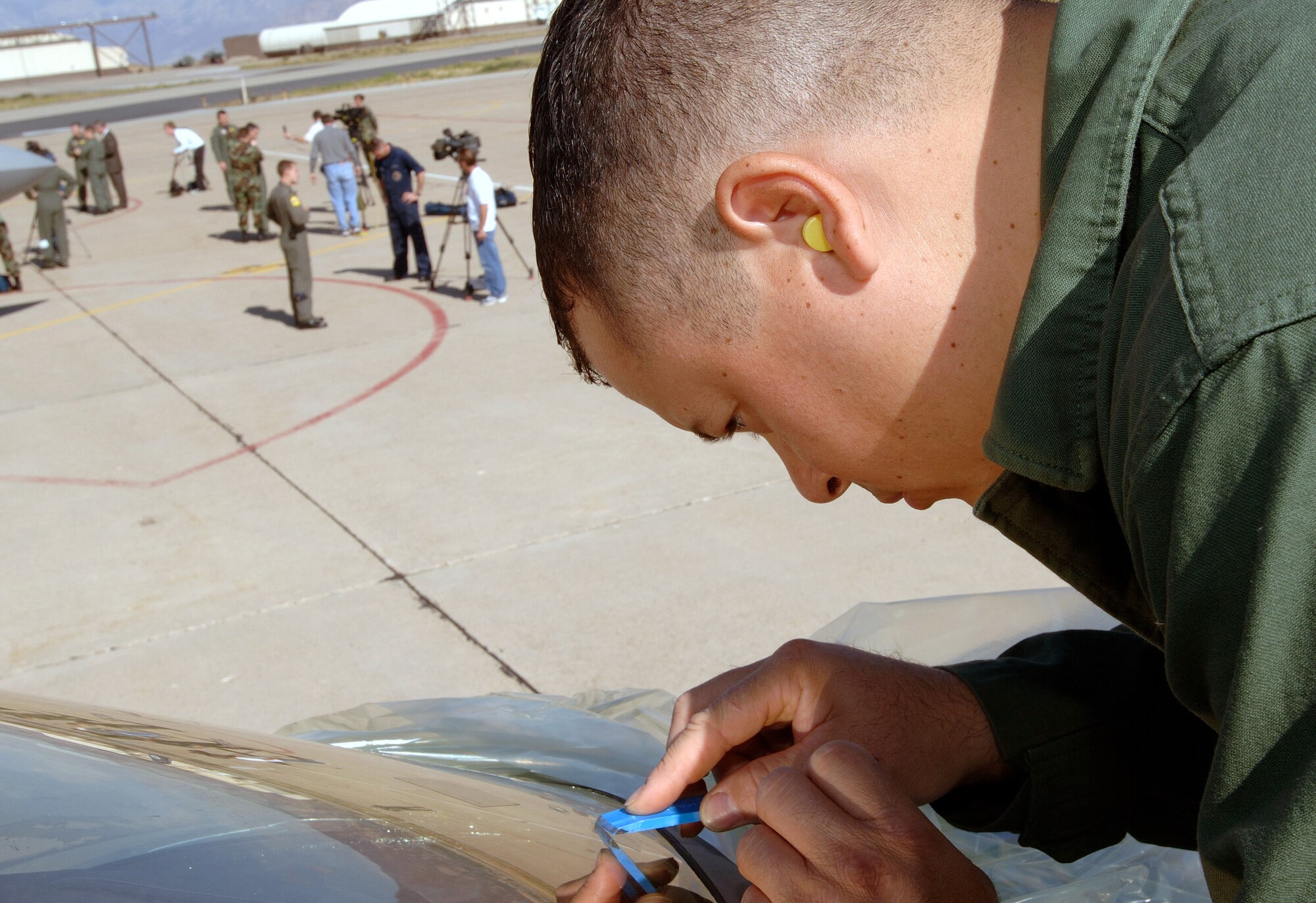 HILL AIR FORCE BASE, Utah -- Staff Sgt. Carlos Sepulveda does a minor repair on the cockpit of an F/A-22 Raptor here. A low observable coding maintainer from Langley Air Force Base, Va., he deployed here Oct. 15 with the 27th Fighter Squadron. The unit deployed here to put the first operational F/A-22 Raptor squadron through the paces in a deployment environment, including live bomb training. (U.S. Air Force photo by Staff Sgt. Samuel Rogers)