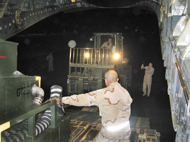 ISLAMABAD, Pakistan -- Members of the 818th Contingency Response Group-Element, McGuire Air Force Base, N.J., and the 437th Airlift Wing, Charleston Air Force Base, S.C., offload airfield operations equipment. Airmen from the units arrived here Oct. 12. (U.S. Air Force photo by 1st Lt. Erick Saks)