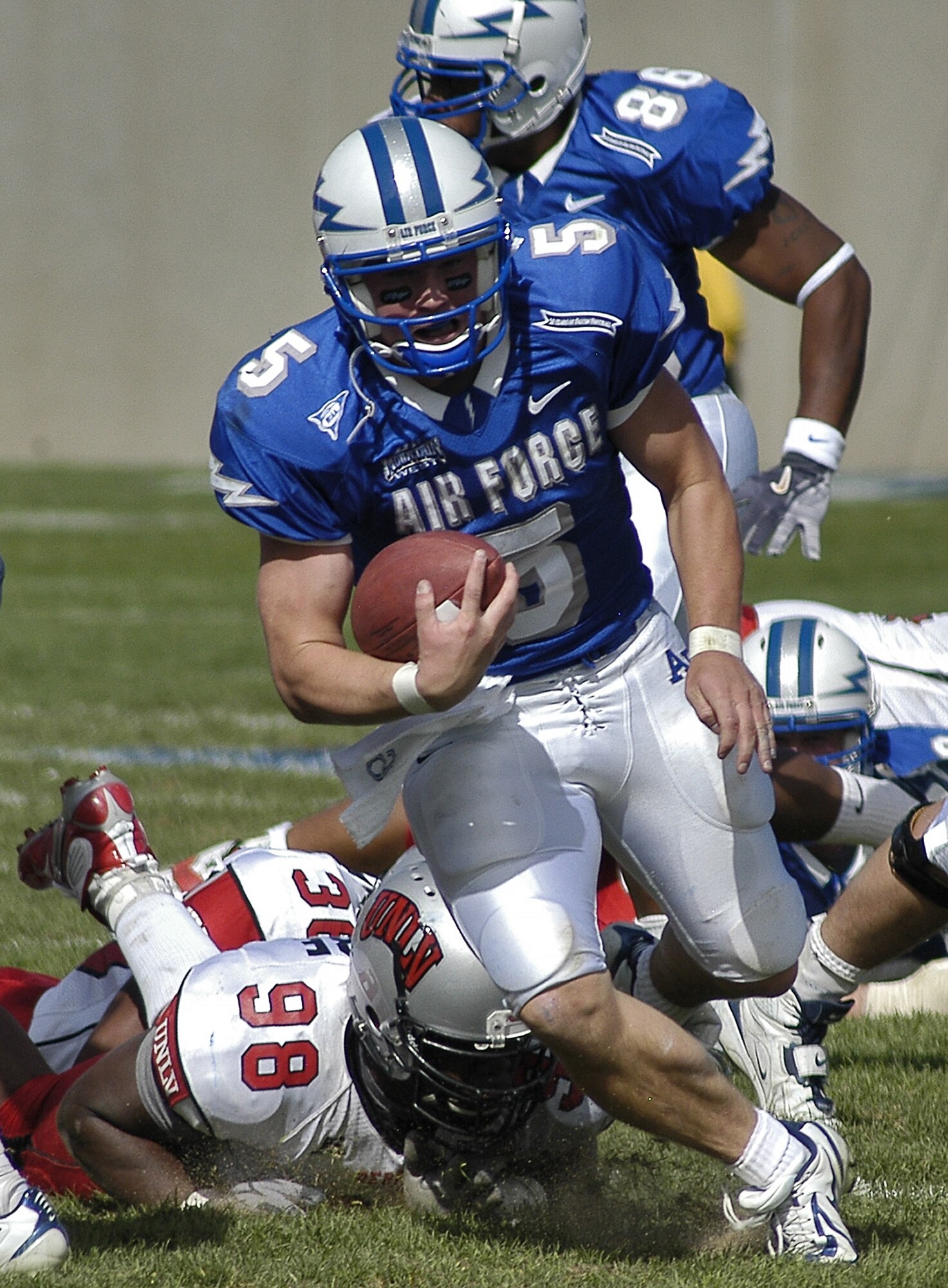 U.S. AIR FORCE ACADEMY, Colo. -- Falcon quarterback Shaun Carney leaves UNLV defensive end Leon Moore, 98, in his wake, as other Falcons provide wingman support. (U.S. Air Force photo by 2nd Lt. John Ross) 
